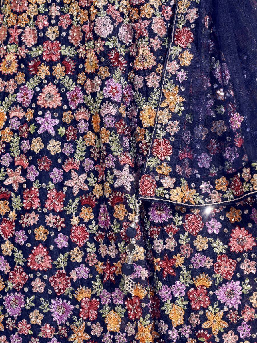 Dark blue ethnic gown with colorful floral embroidery and mirror work, perfect for Indian occasions.