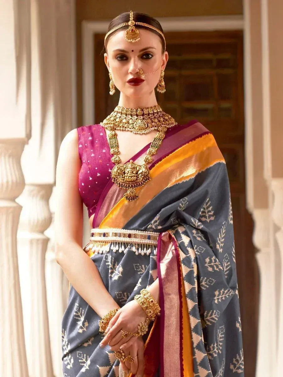 Elegant woman in traditional Indian saree with gold jewelry and intricate patterns