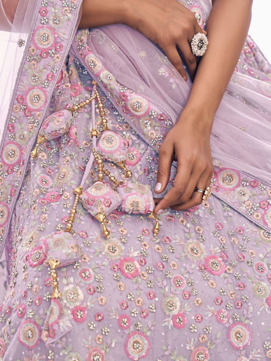 Lavender designer lehenga with floral embroidery and gold tassels, perfect for Indian ethnic wear