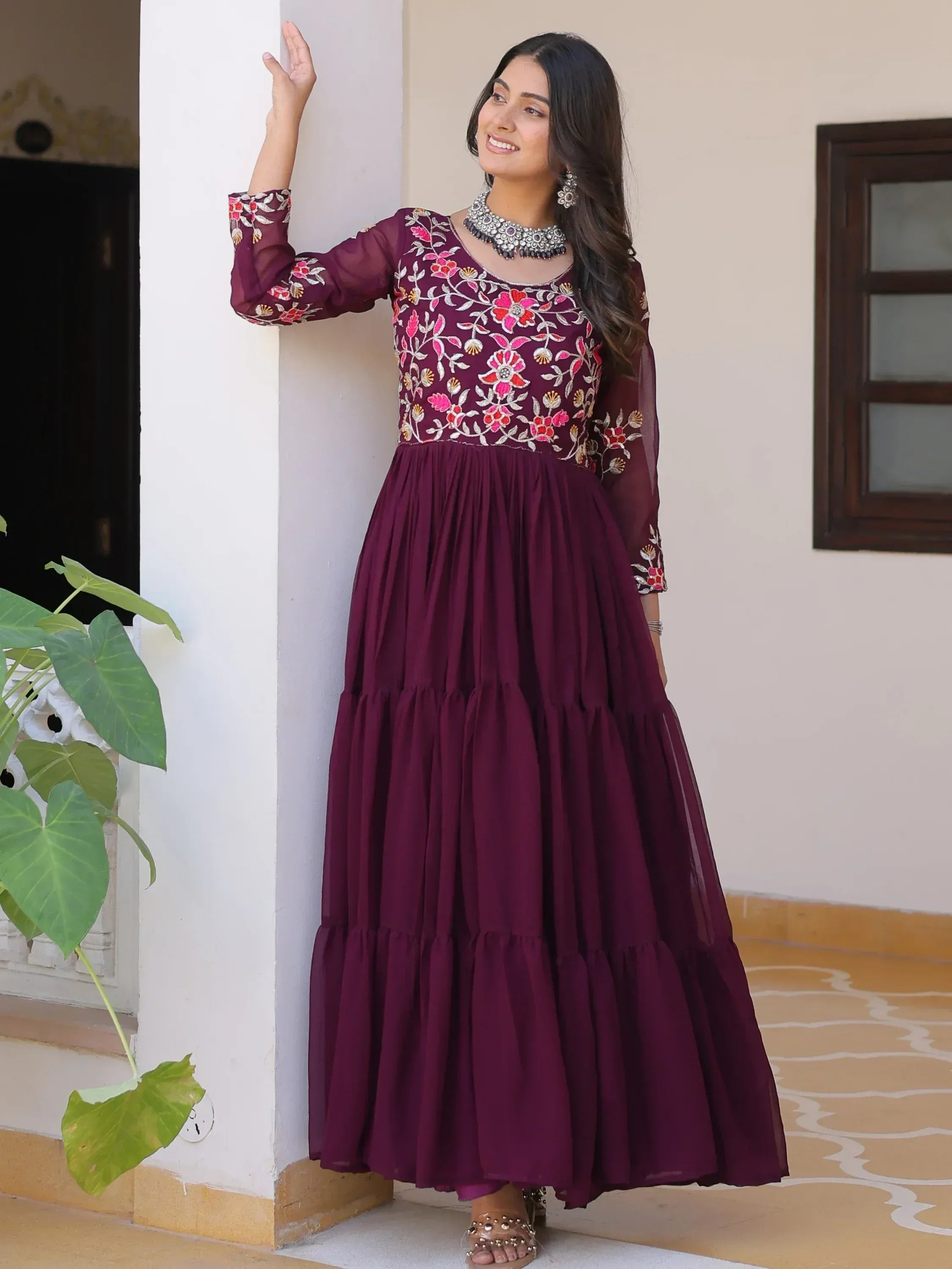 Woman in maroon embroidered ethnic gown with floral design, perfect for Indian occasions