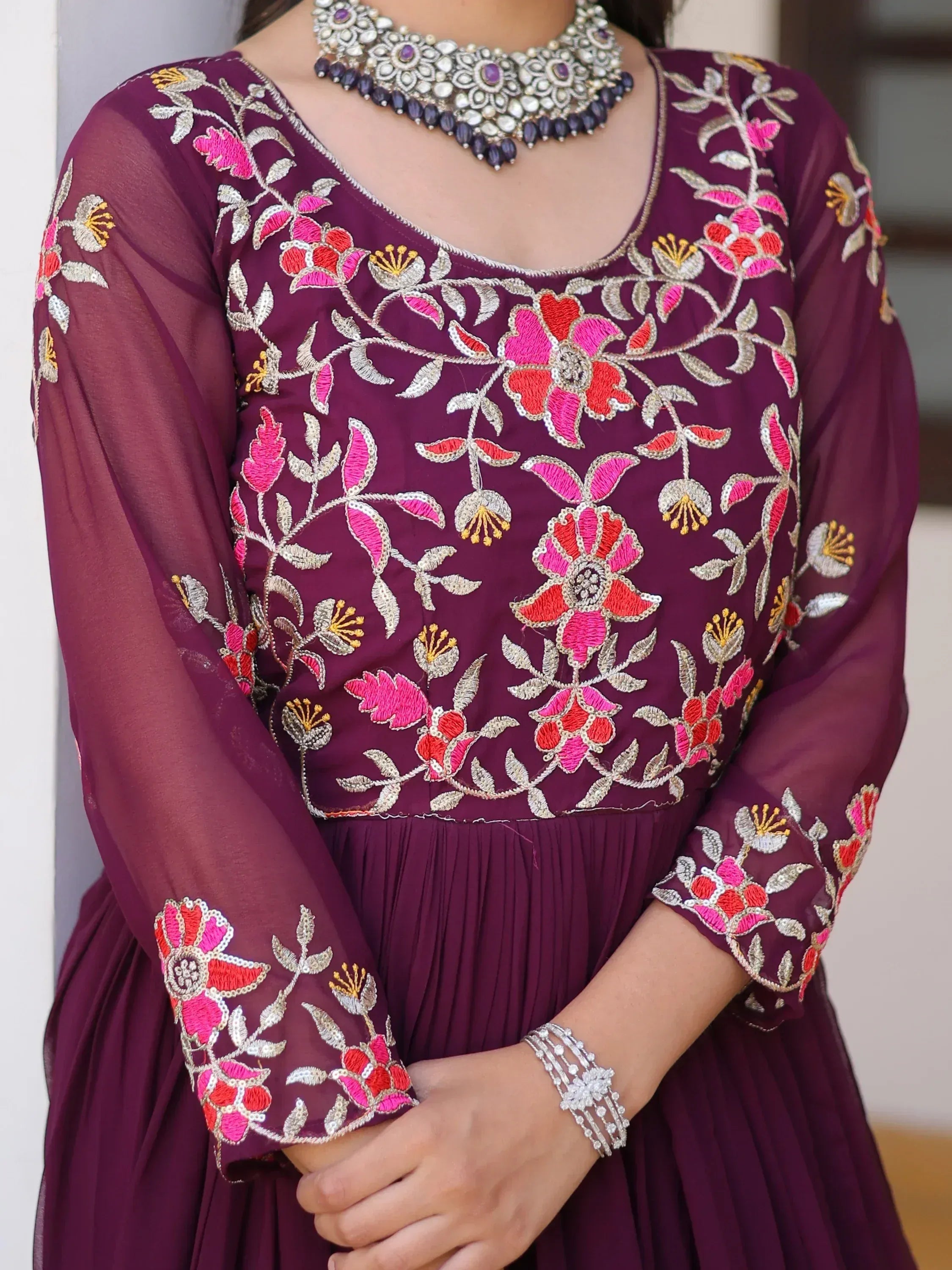 Purple ethnic gown with vibrant floral embroidery and silver jewelry, perfect for Indian festive occasions.