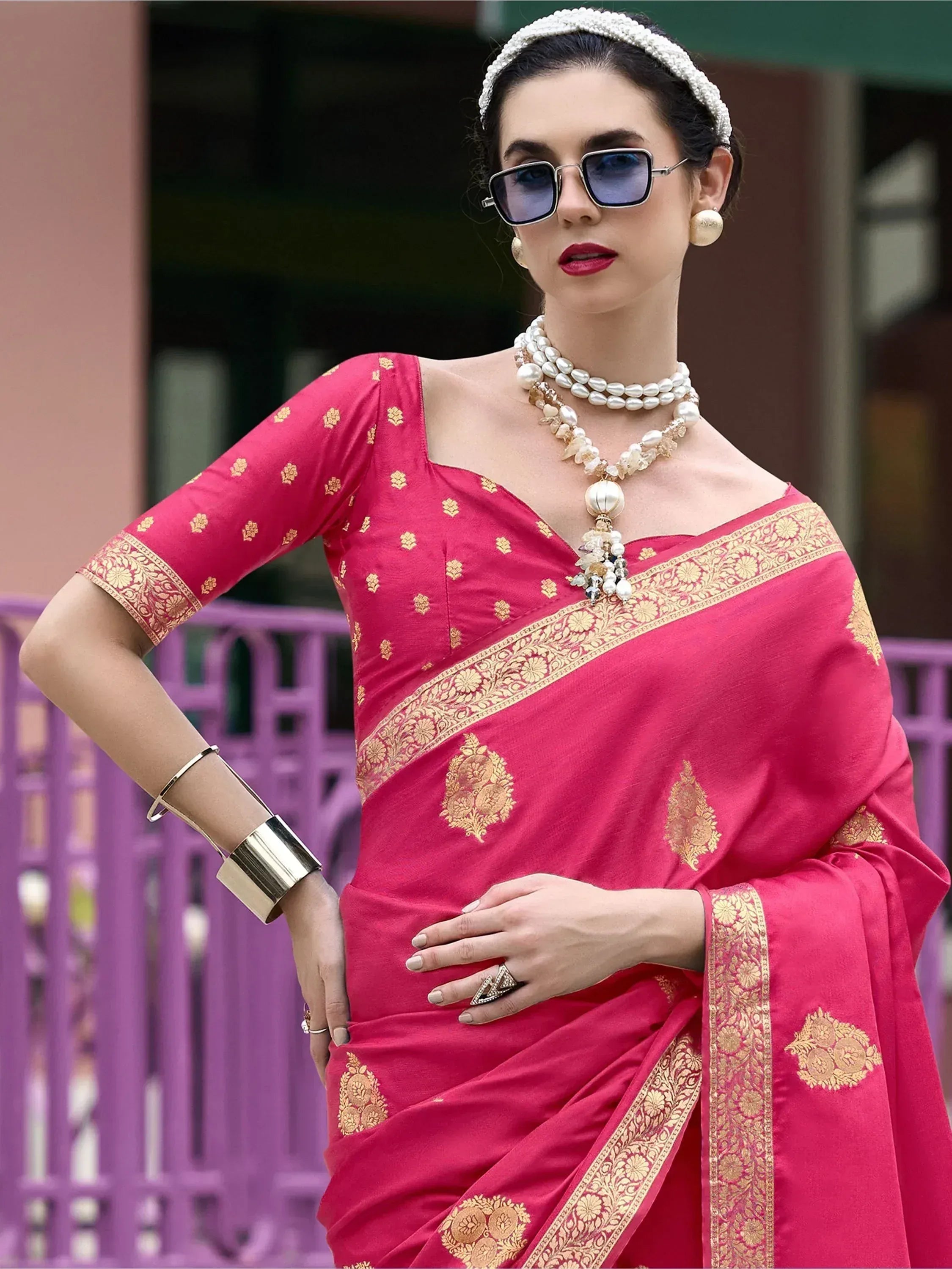 Pink ethnic saree with gold embroidery, styled with pearl jewelry and sunglasses for a modern look