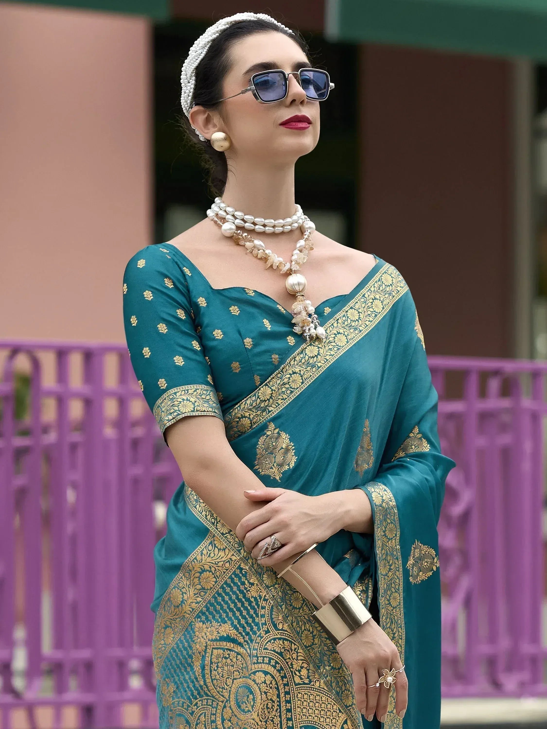 Teal saree with gold embroidery, pearl jewelry, and sunglasses for ethnic wear