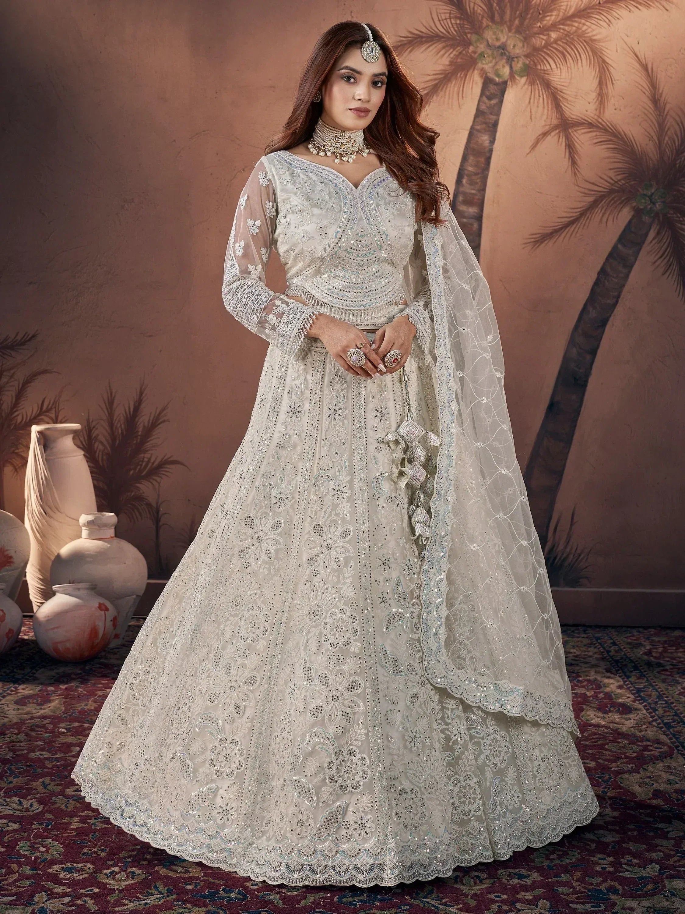 Elegant white embroidered lehenga choli with sheer dupatta, perfect for Indian weddings and festive occasions.