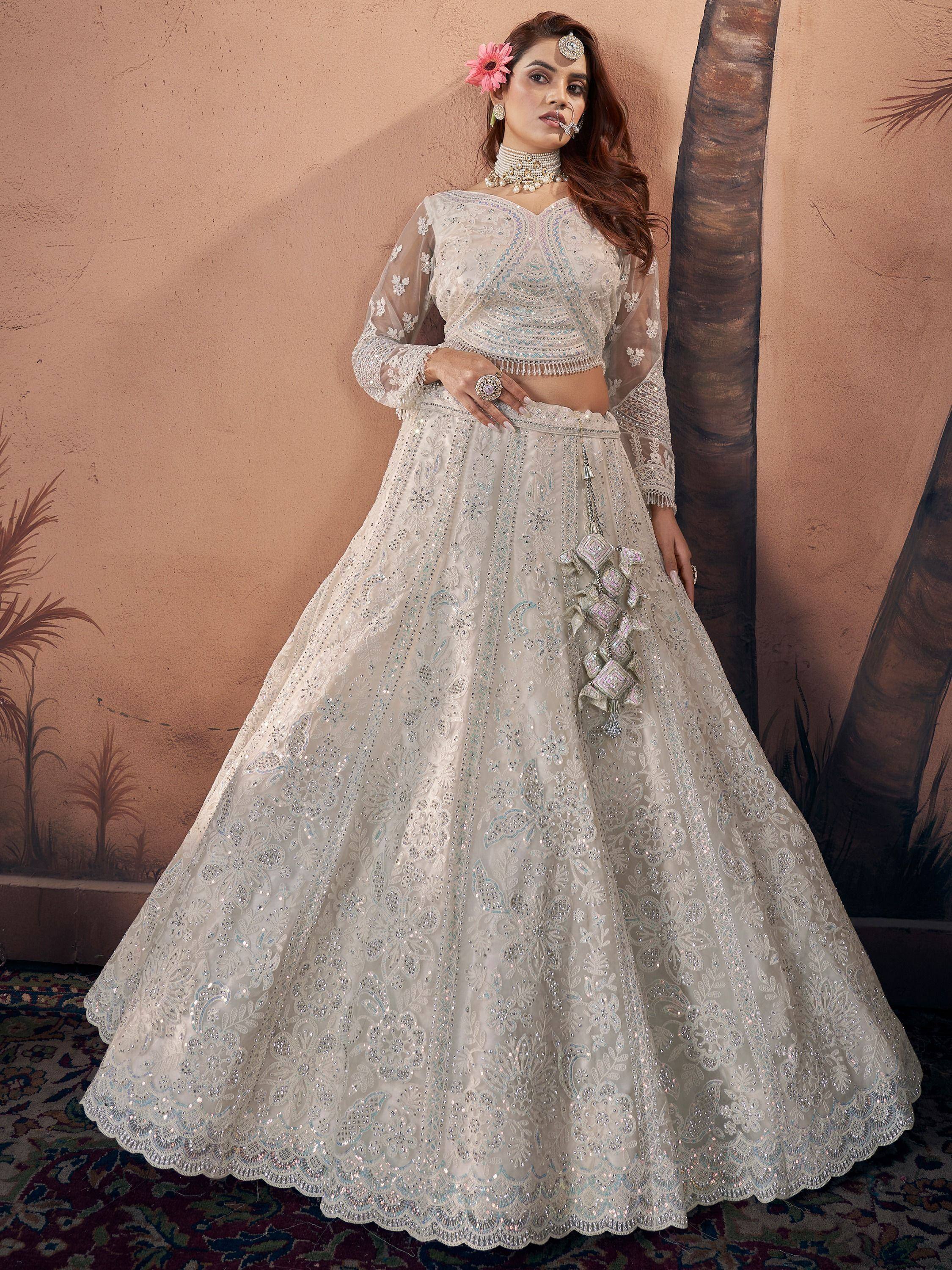 Elegant white embroidered lehenga choli with sheer sleeves, perfect for Indian weddings and festive occasions.