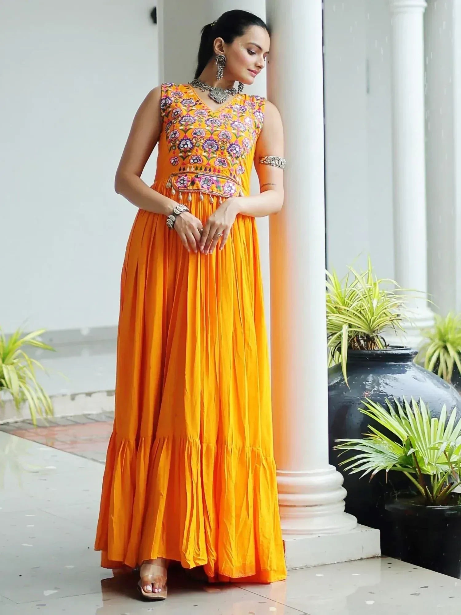 Vibrant orange ethnic gown with floral embroidery, perfect for Indian celebrations and festive occasions.