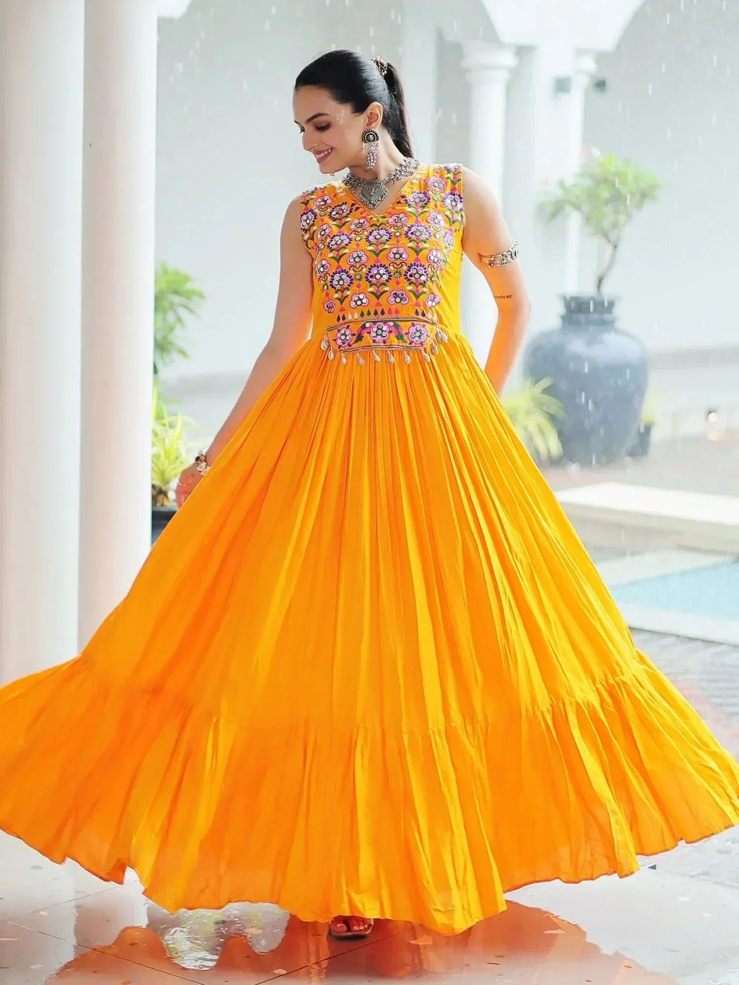 Vibrant yellow ethnic gown with floral embroidery, perfect for festive occasions and celebrations.