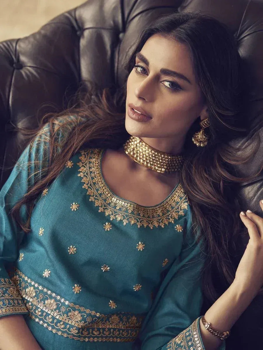 Teal embroidered ethnic kurti with gold detailing, paired with traditional jewelry, perfect for Indian festive wear.