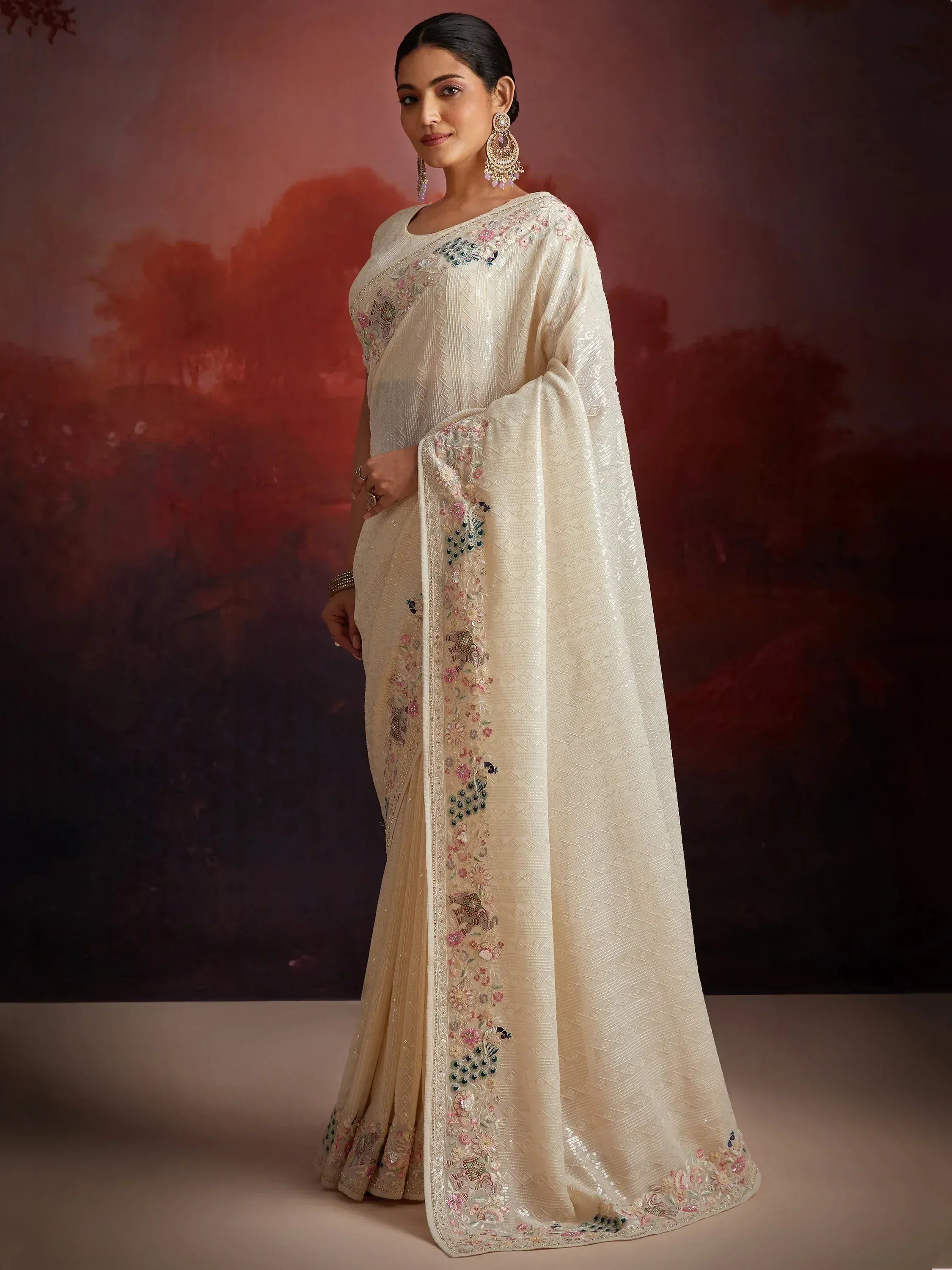 Cream embroidered saree with floral and peacock motifs, perfect for Indian ethnic wear occasions.