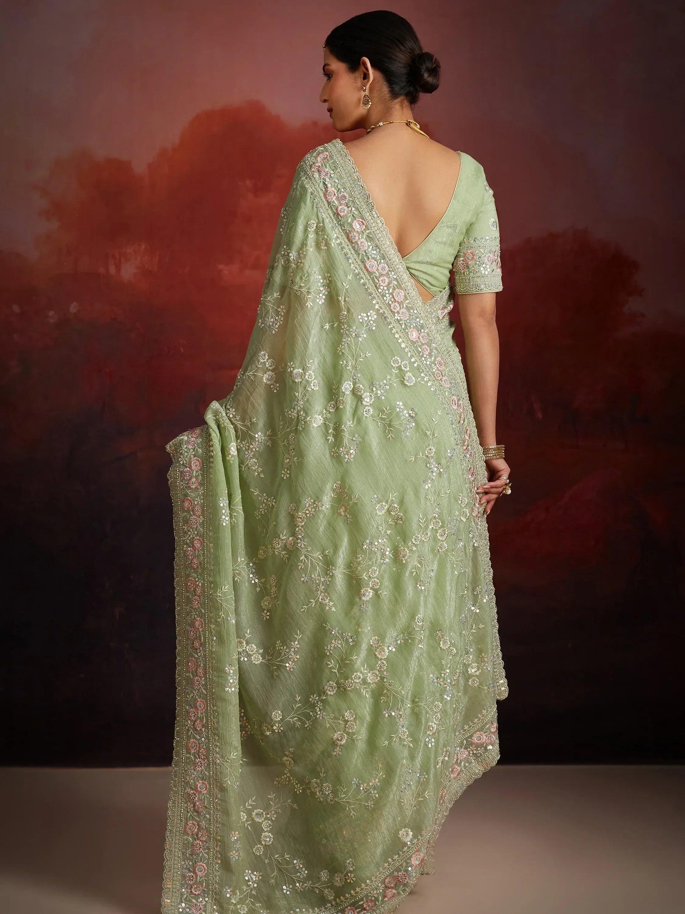 Light green embroidered saree with floral motifs and scalloped border, back view