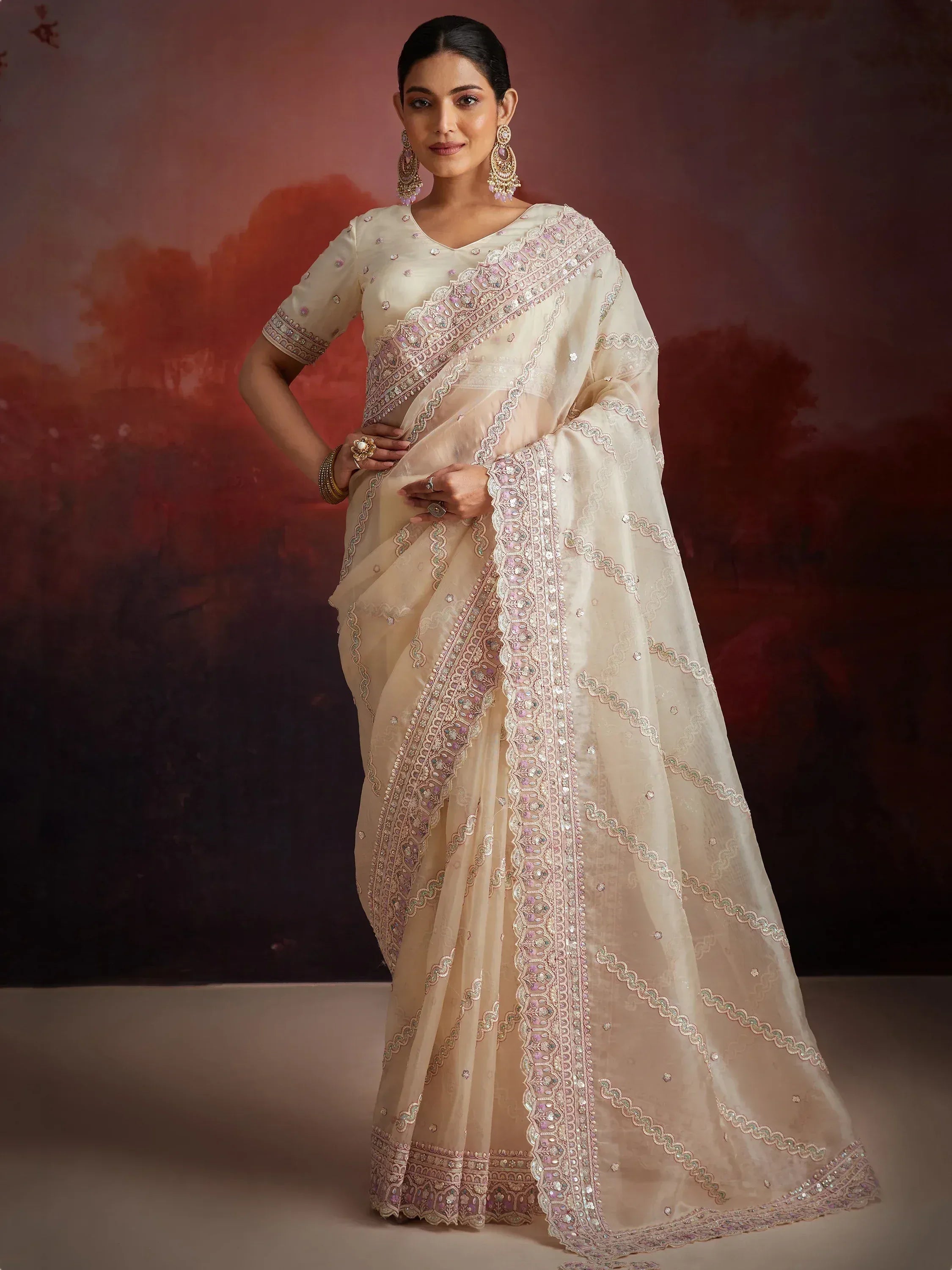 Elegant cream saree with pink and gold embroidery, perfect for Indian ethnic occasions and weddings.