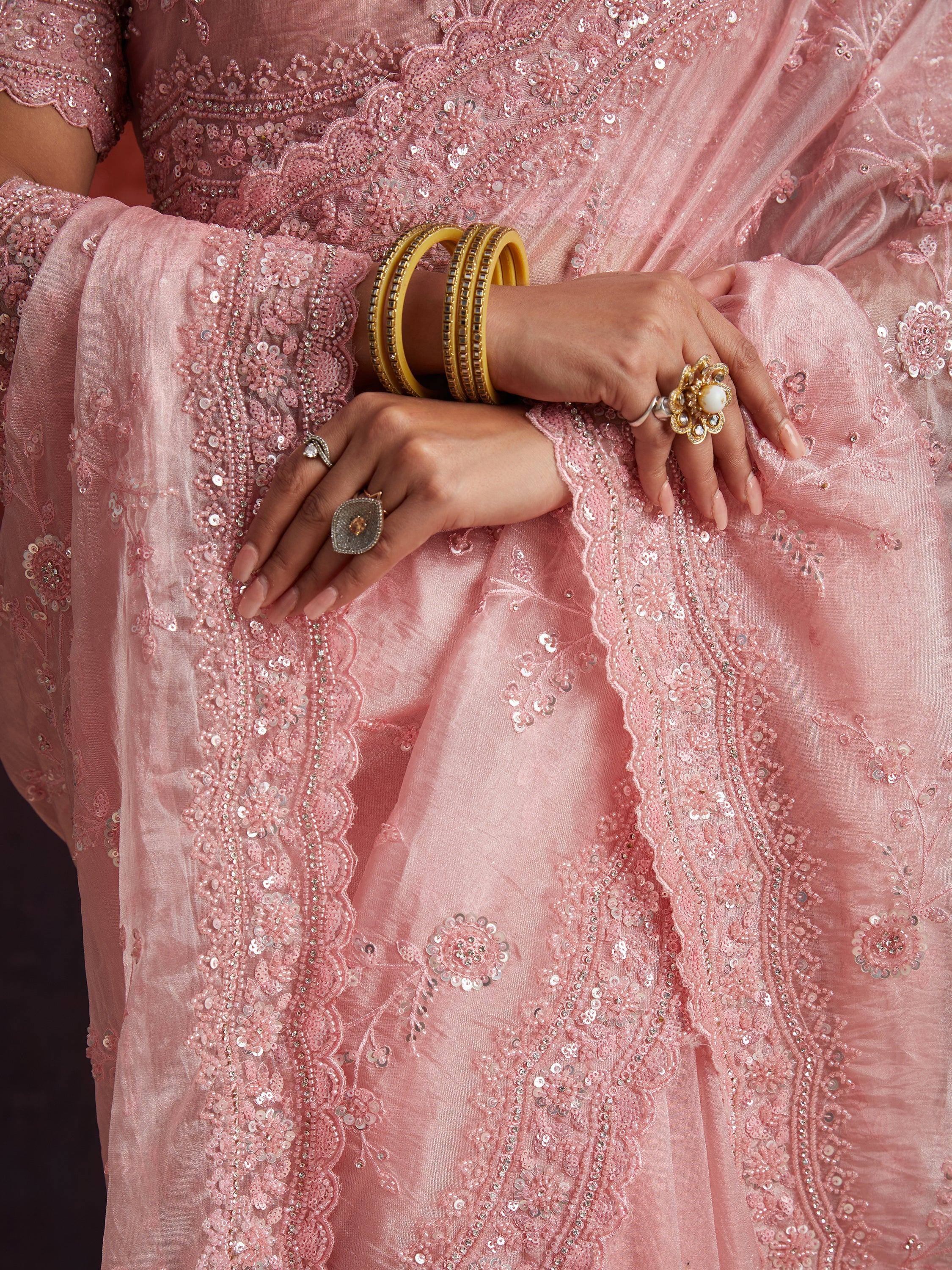 Pink embroidered ethnic gown with sequins, beads, and gold bangles for festive occasions
