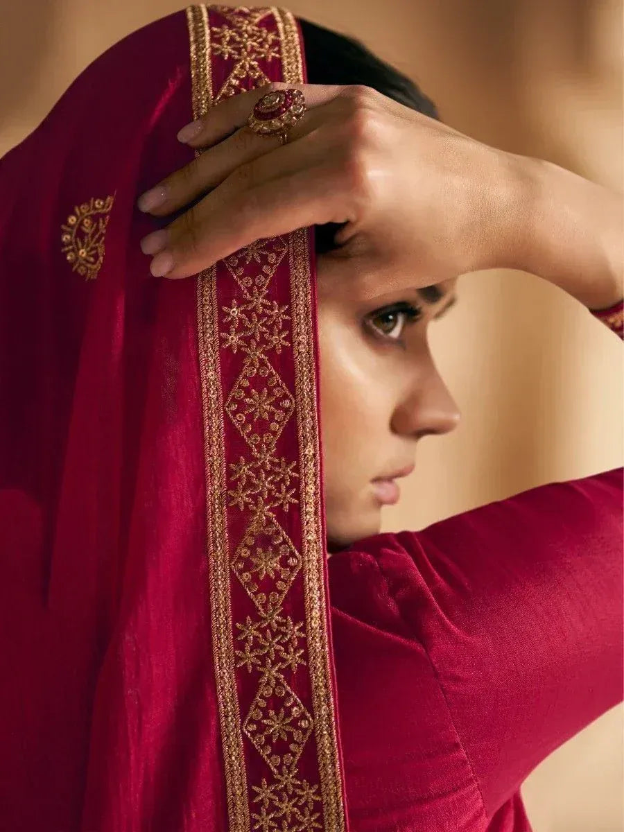 Woman in maroon ethnic wear with gold embroidery, showcasing designer Indian attire