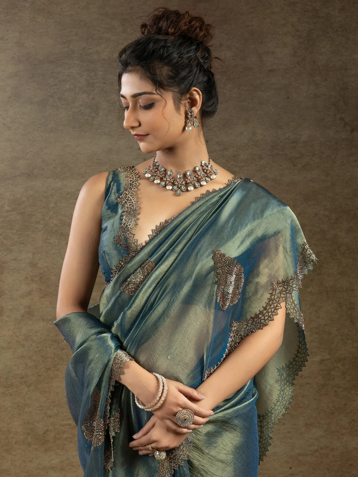 Elegant teal saree with gold embroidery, paired with statement jewelry for Indian ethnic wear