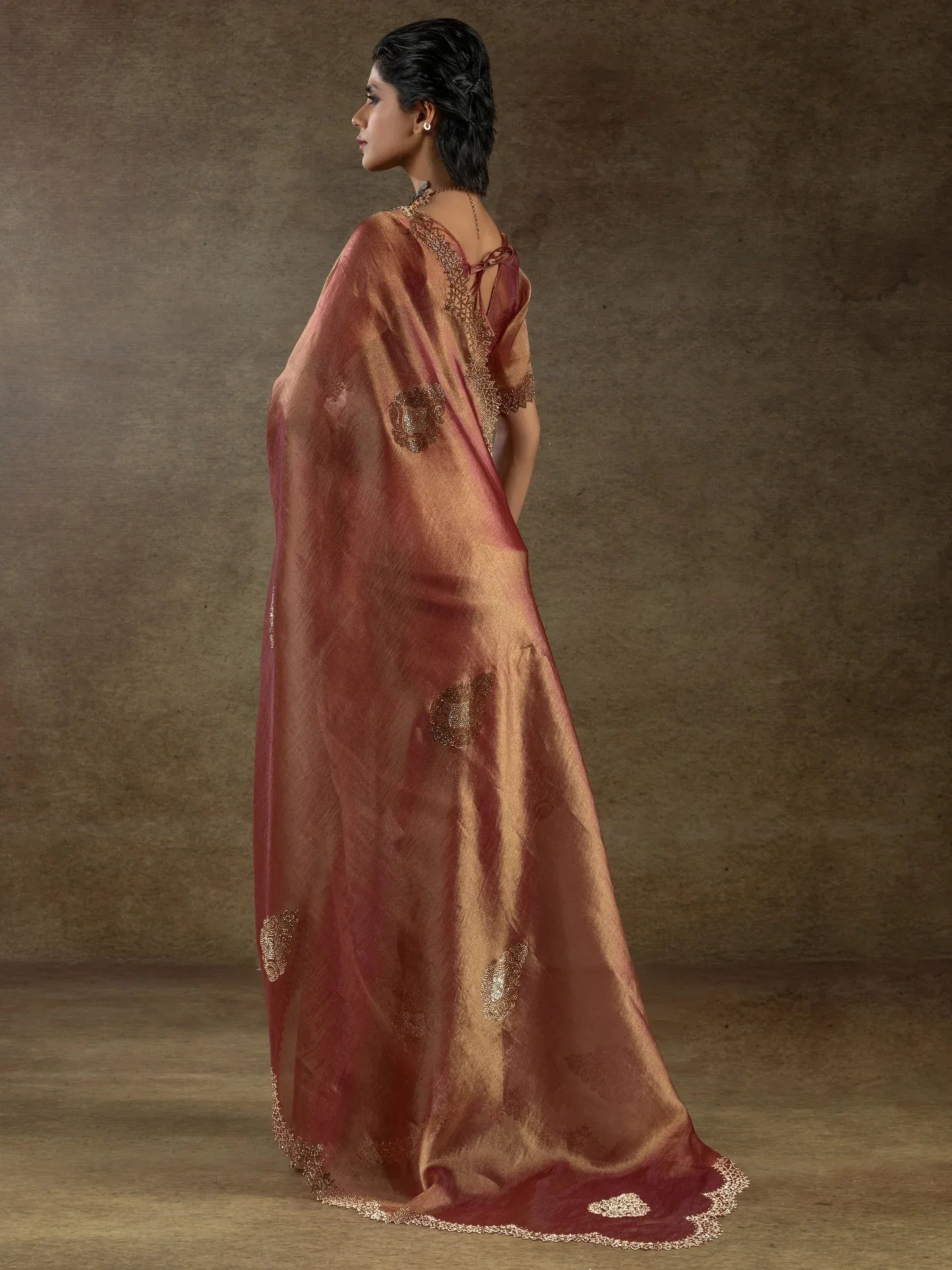 Elegant maroon and gold saree with intricate embroidery and embellishments for ethnic wear