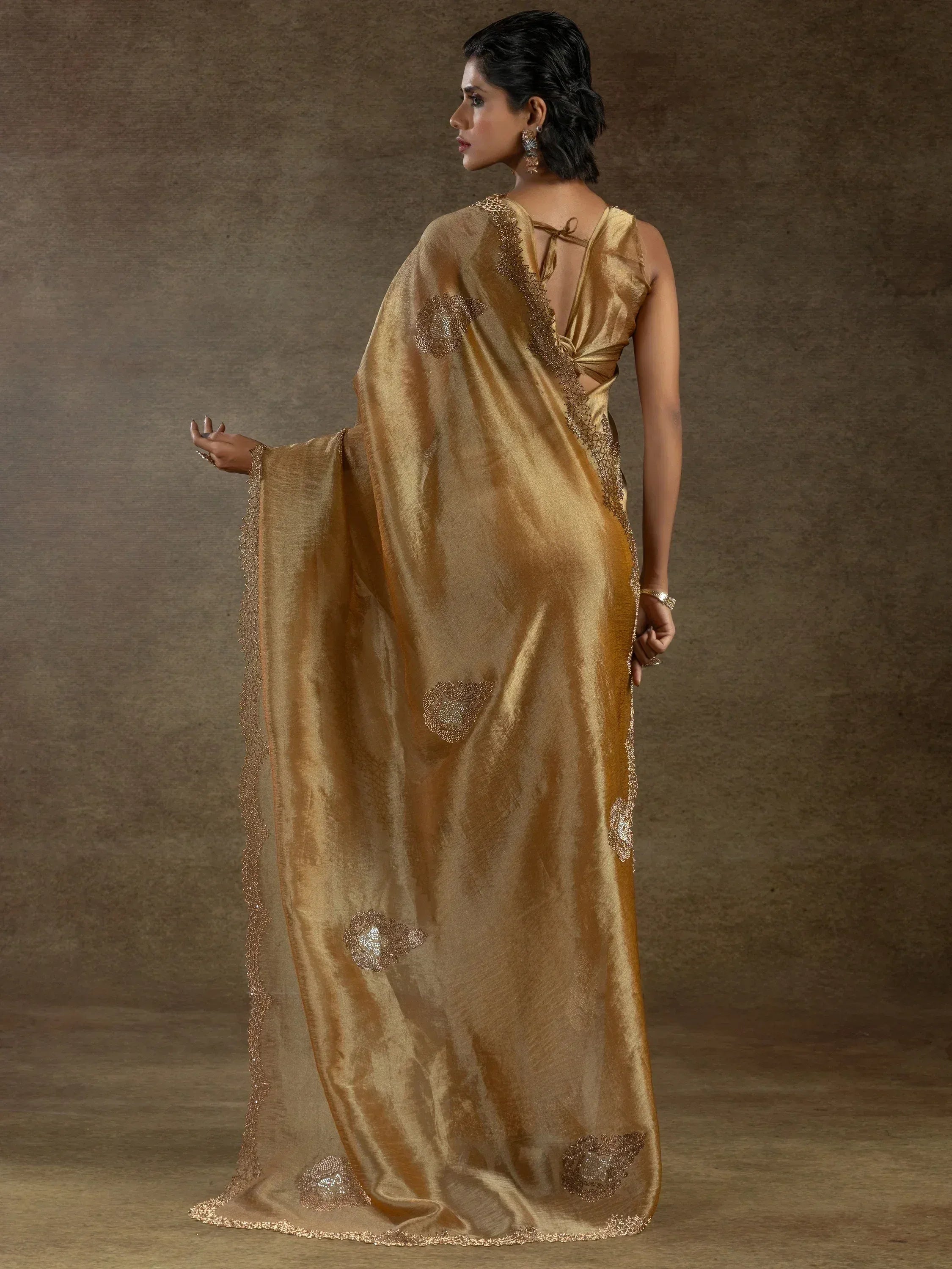 Elegant gold saree with intricate embroidery and shimmering details, perfect for ethnic occasions.