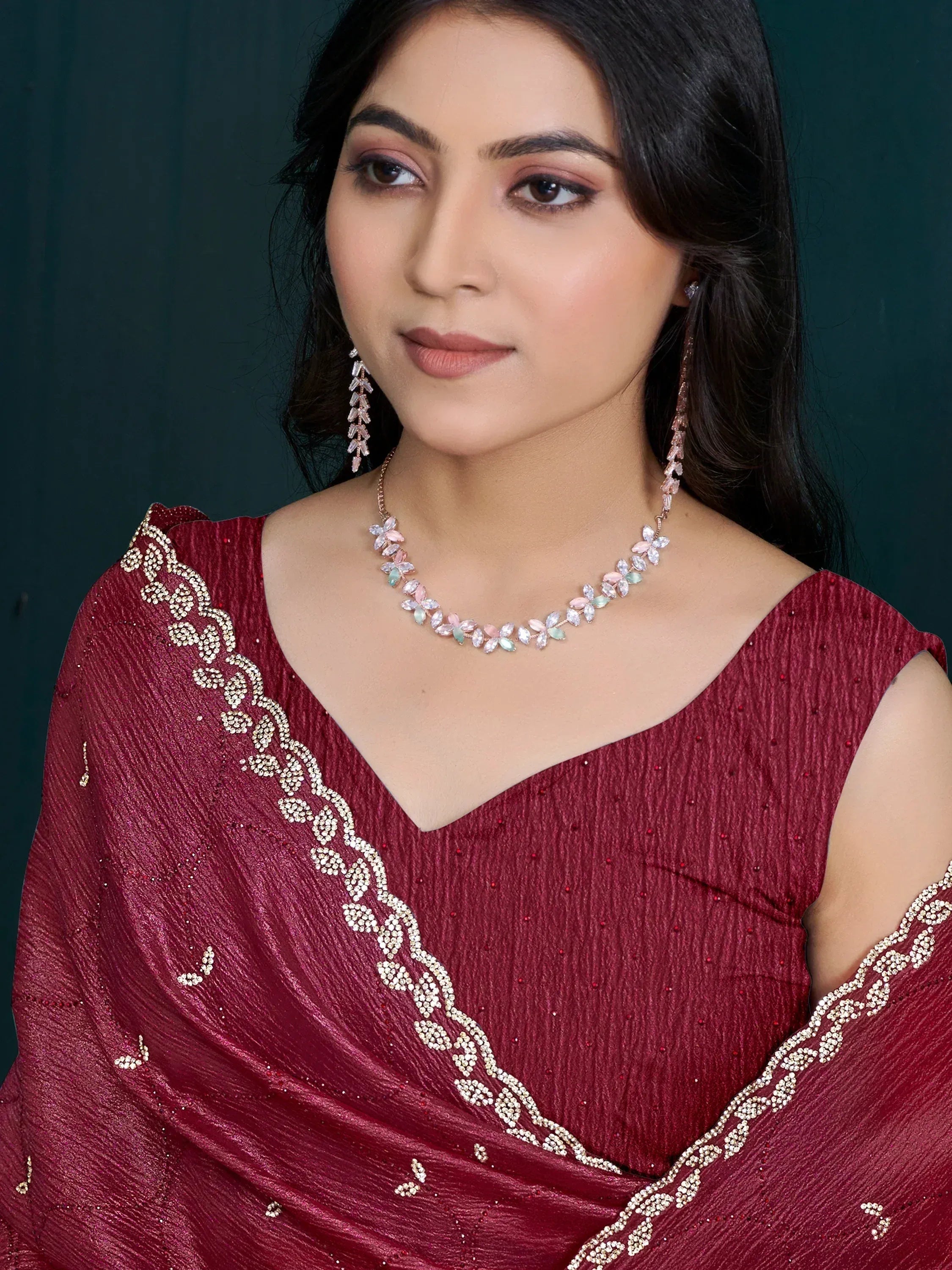 Woman in maroon ethnic gown with floral necklace and earrings, perfect for Indian festive occasions
