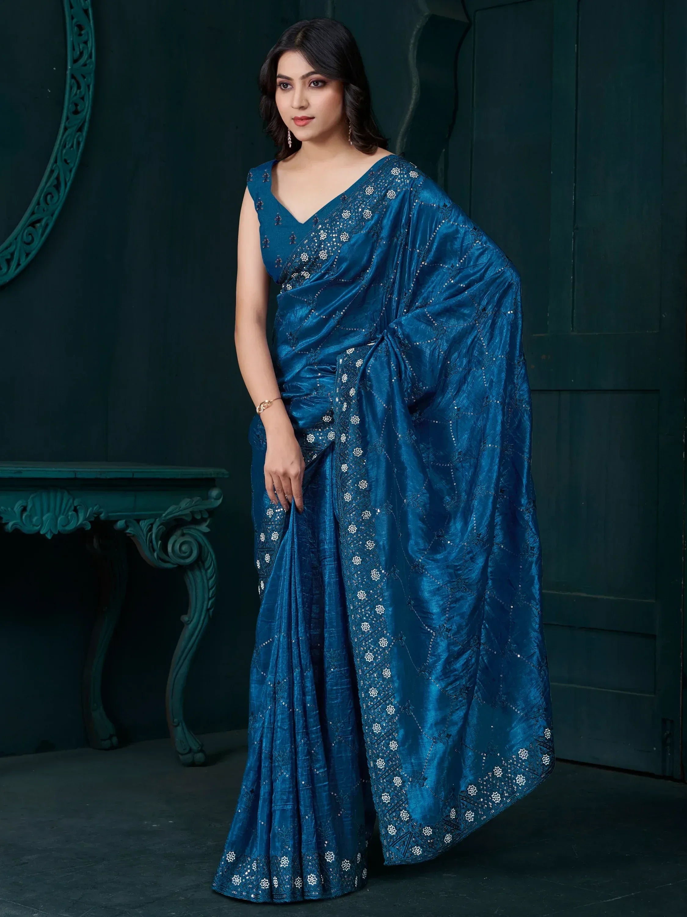Elegant blue saree with intricate white embroidery and sequin detailing, perfect for festive occasions.