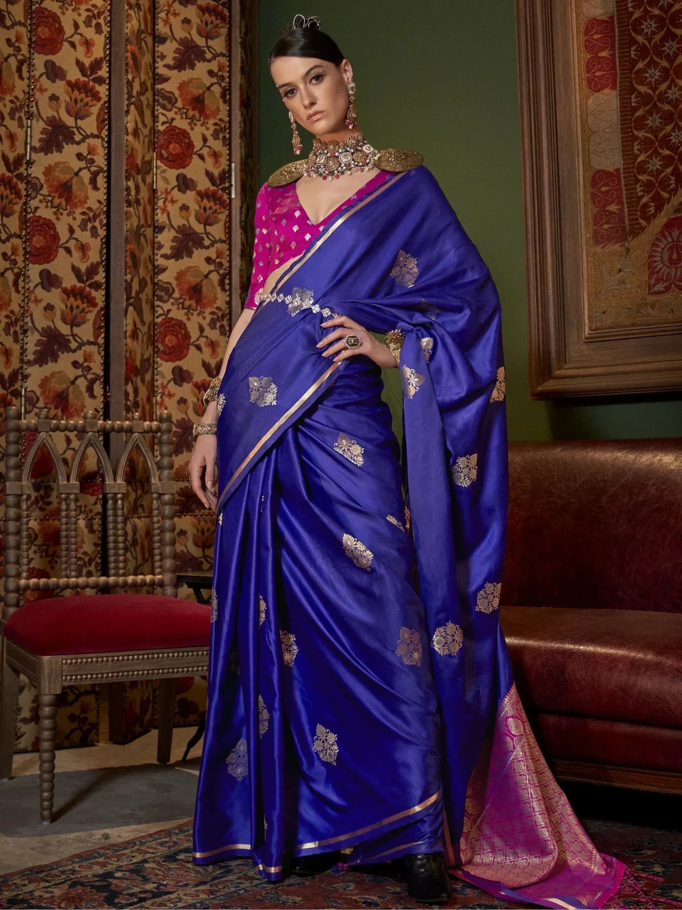 Royal blue silk saree with gold floral motifs and pink blouse, styled with traditional Indian jewelry for ethnic wear.
