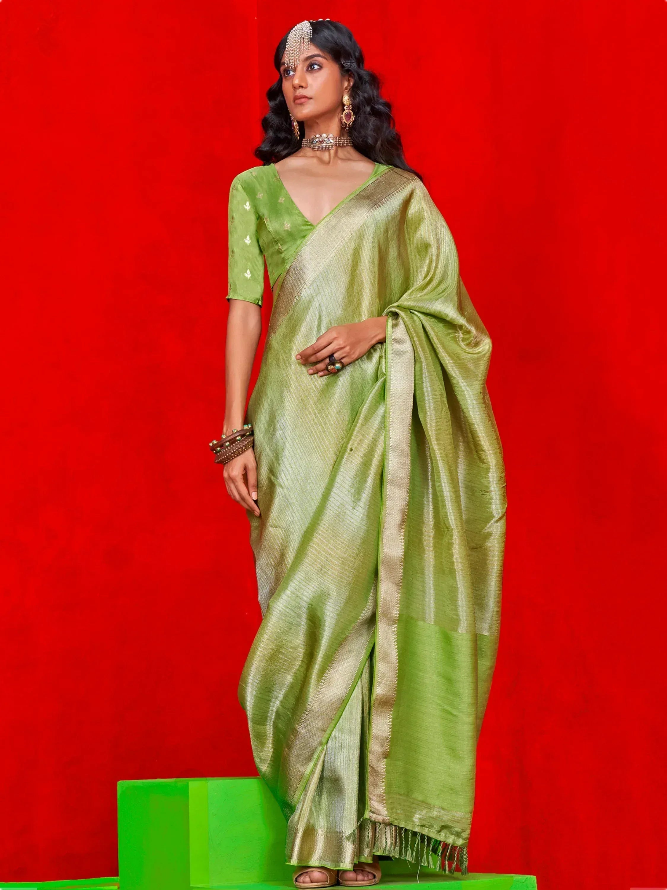 Elegant green silk saree with gold border, paired with matching blouse and traditional jewelry for Indian ethnic wear.