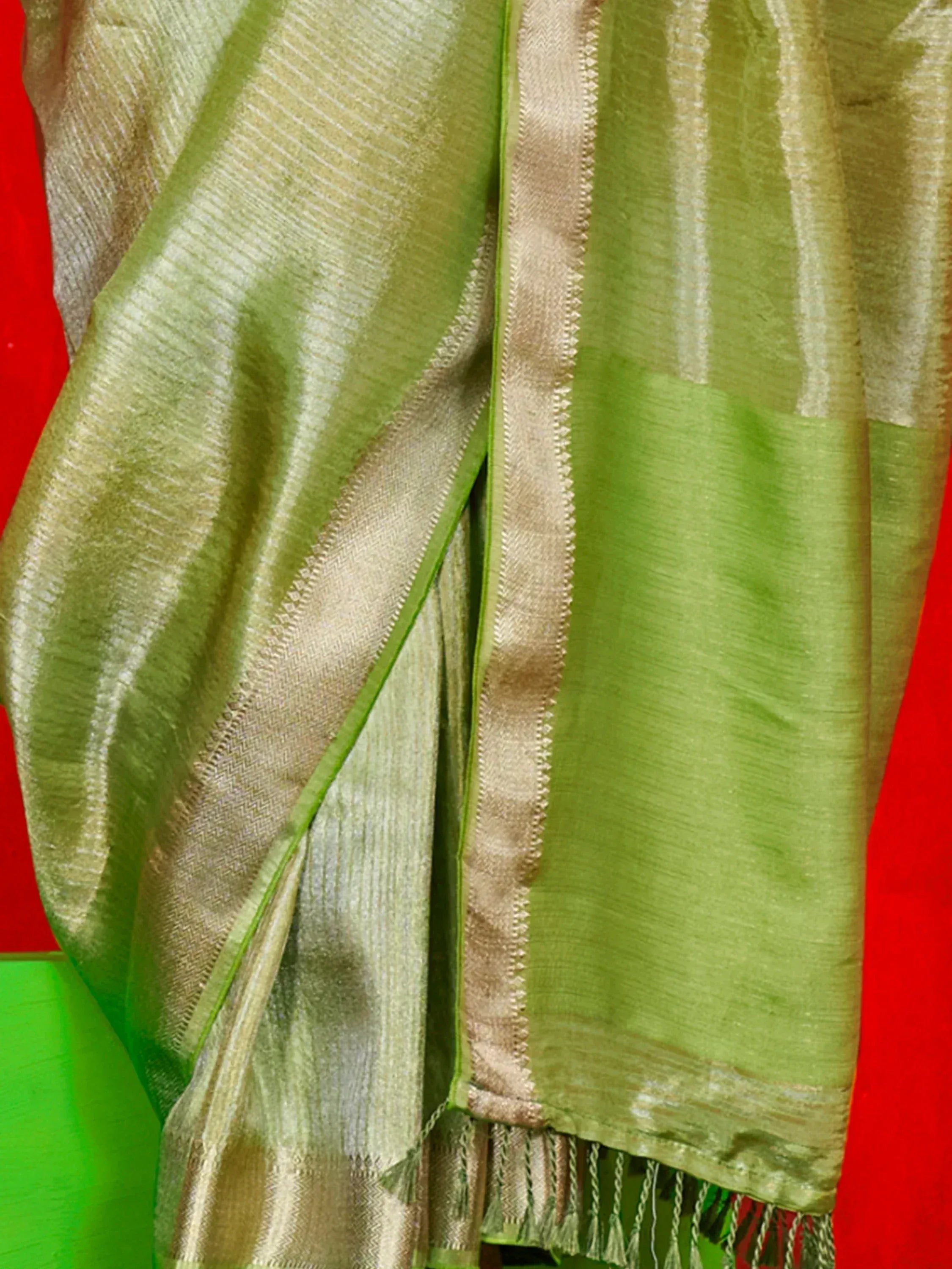 Green and gold striped ethnic saree with woven border and tassels, ideal for Indian festive occasions