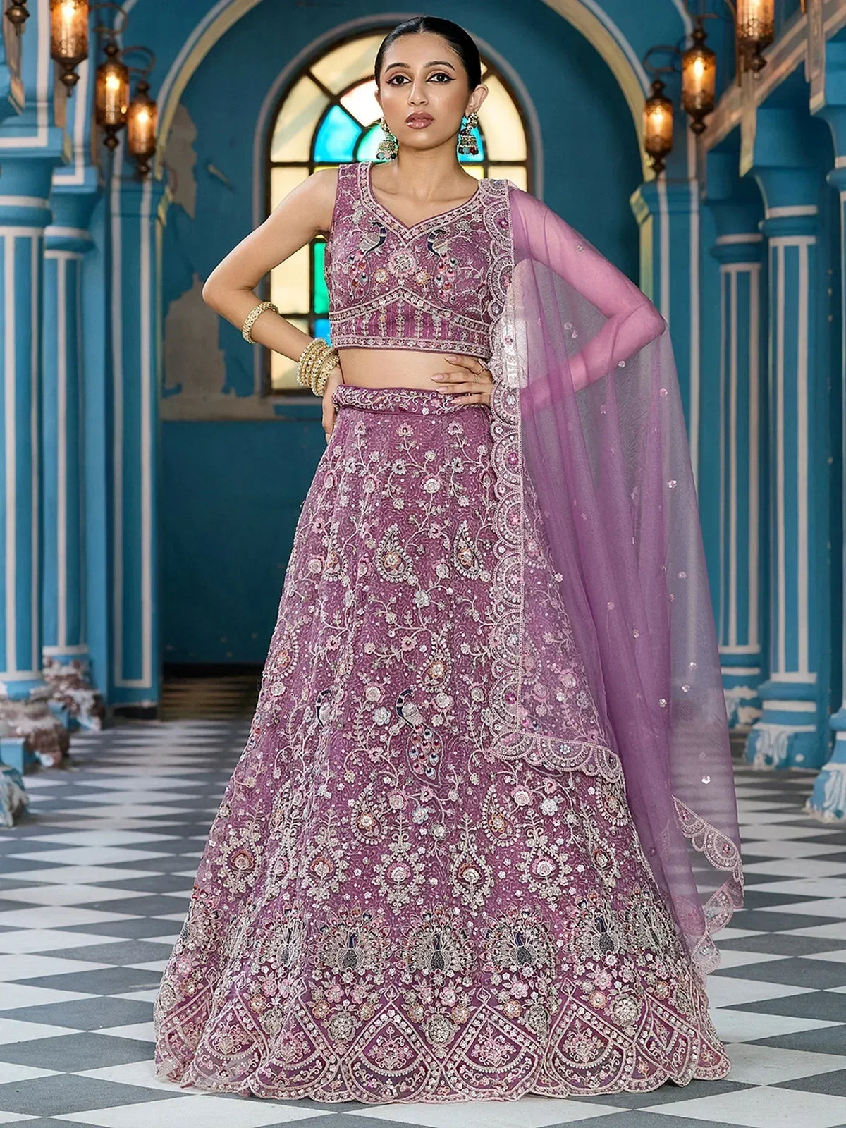 Elegant purple embroidered lehenga choli with intricate floral designs and sheer dupatta for Indian ethnic wear