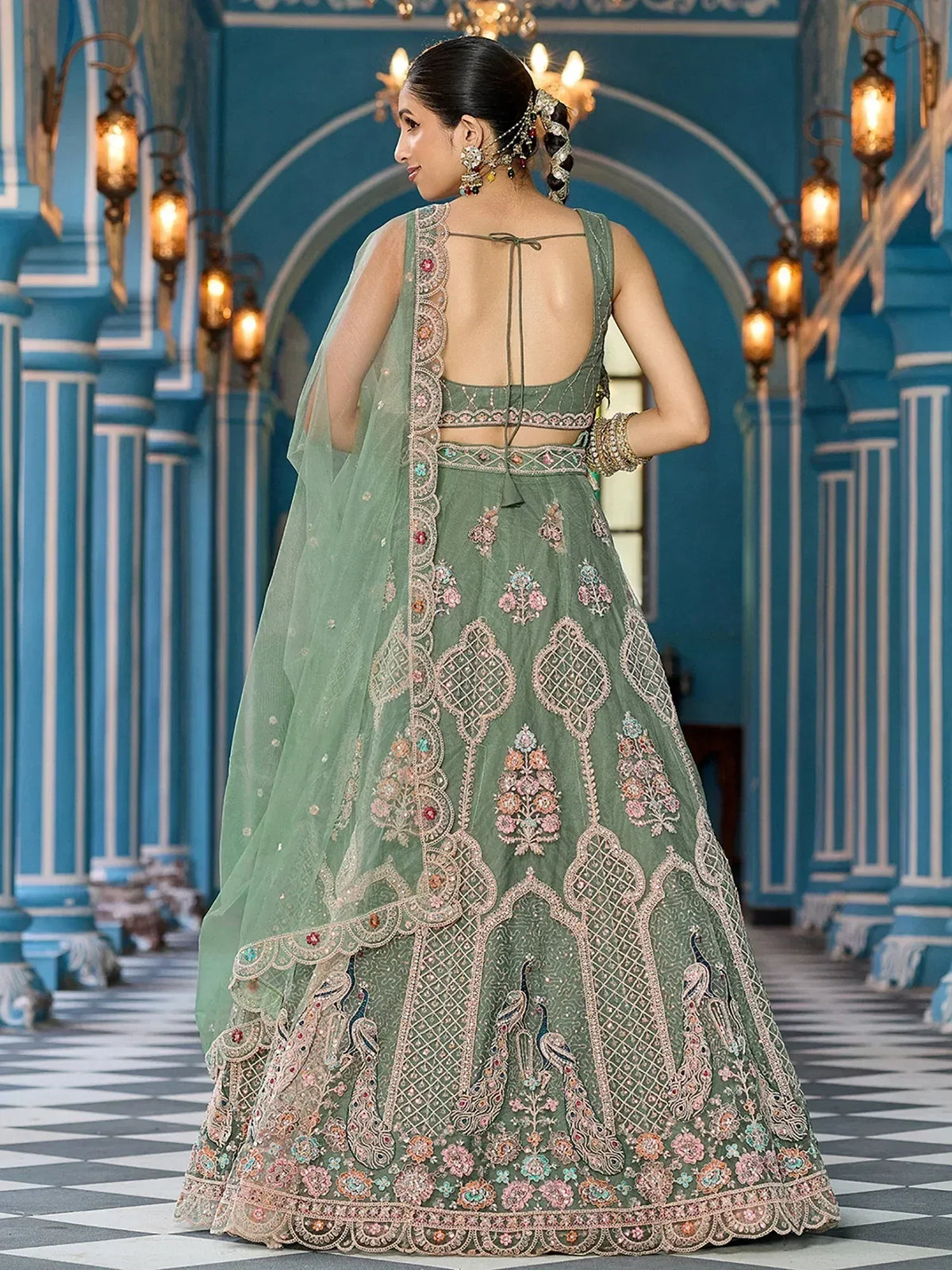 Elegant sage green lehenga choli with floral and peacock embroidery, perfect for Indian weddings and festive occasions.