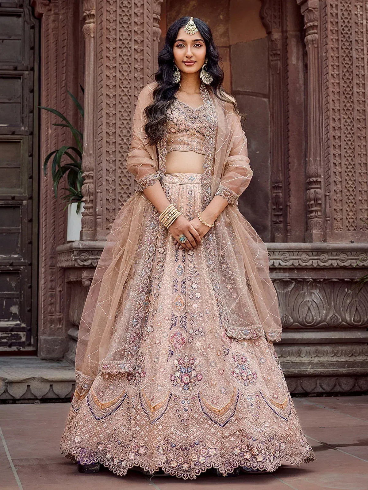 Elegant beige embroidered lehenga choli with floral motifs and sheer dupatta, perfect for Indian weddings.