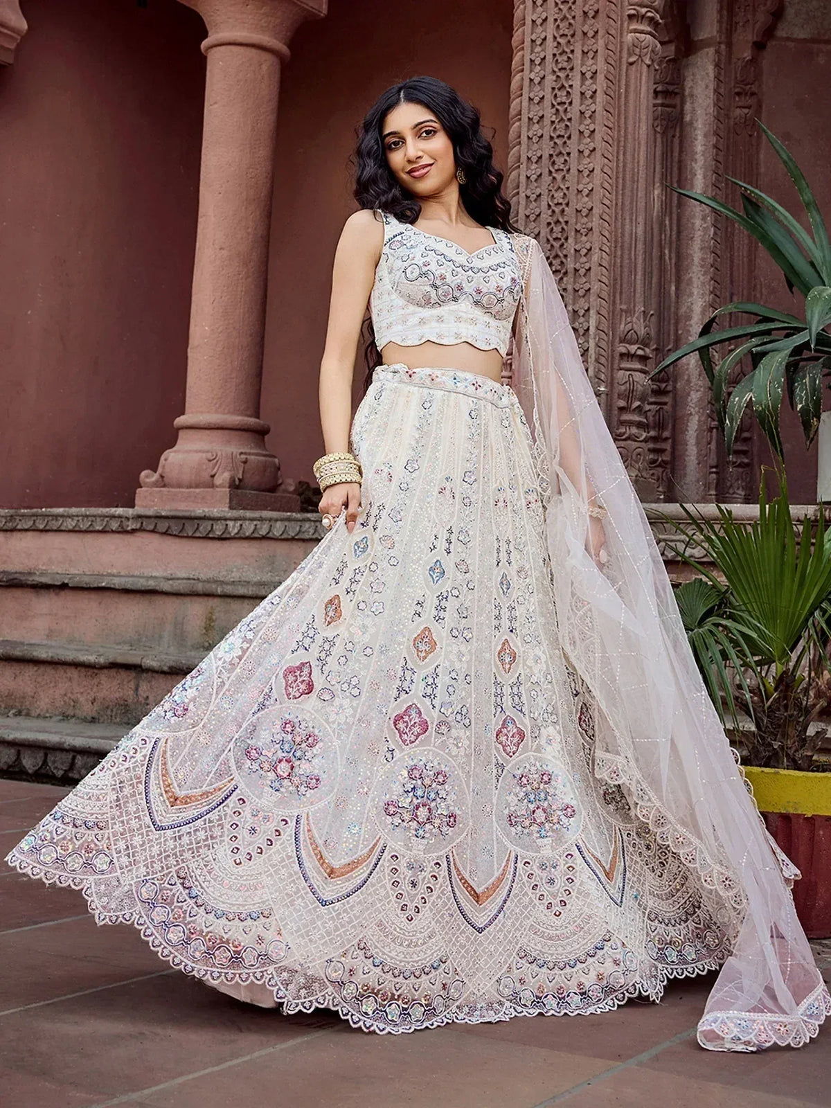 Elegant white embroidered lehenga choli with floral patterns and sheer dupatta, perfect for Indian ethnic wear.