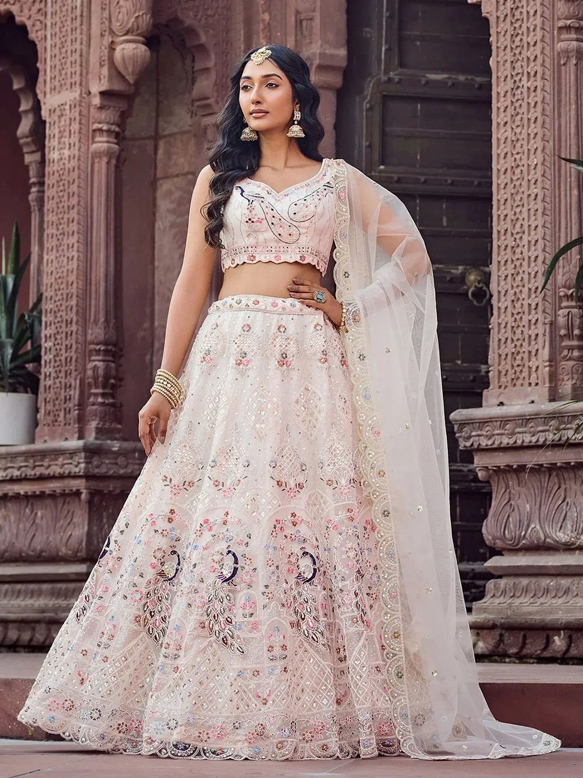 Elegant white lehenga choli with peacock embroidery and floral motifs, perfect for Indian ethnic wear.