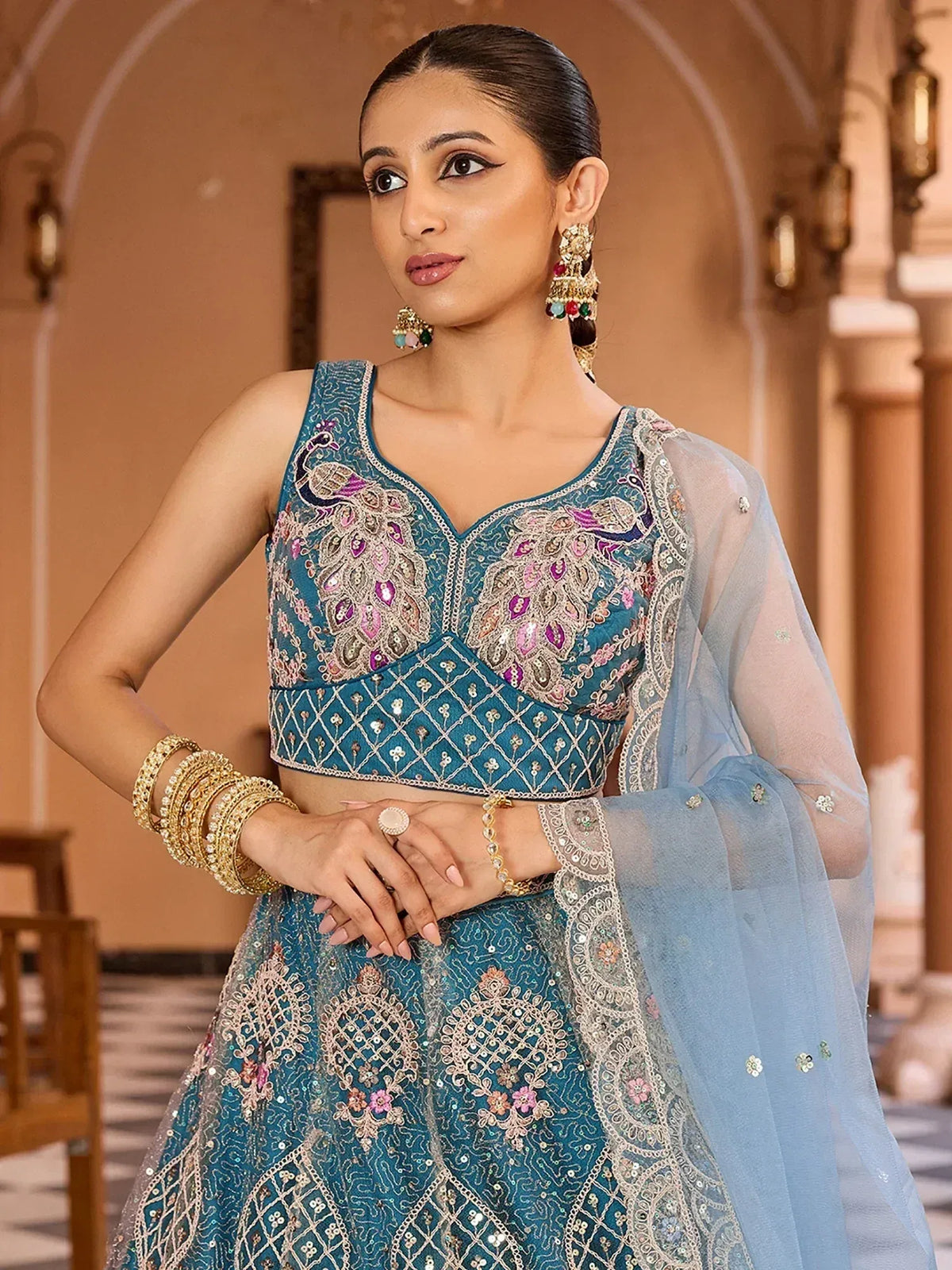 Elegant teal lehenga choli with peacock embroidery and sheer dupatta, perfect for Indian ethnic wear.