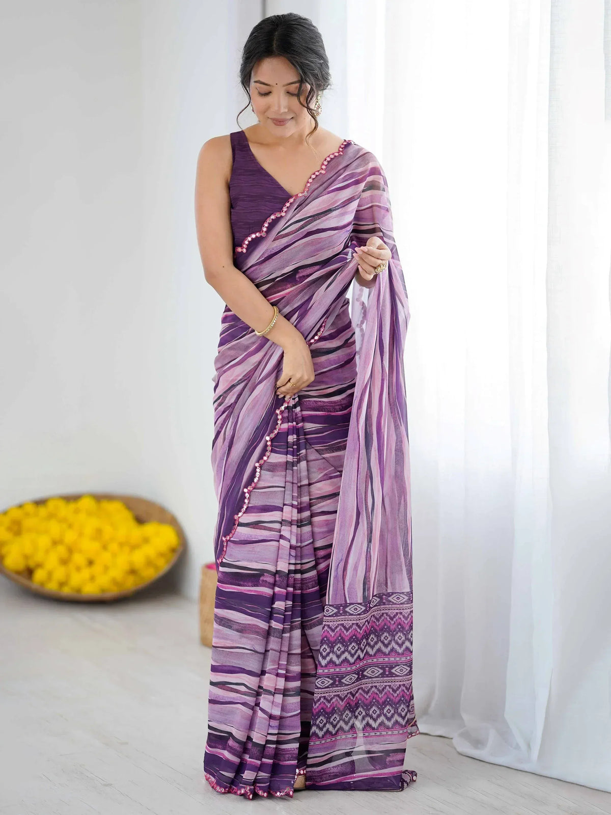 Purple and pink striped saree with geometric border, styled with sleeveless blouse for ethnic wear