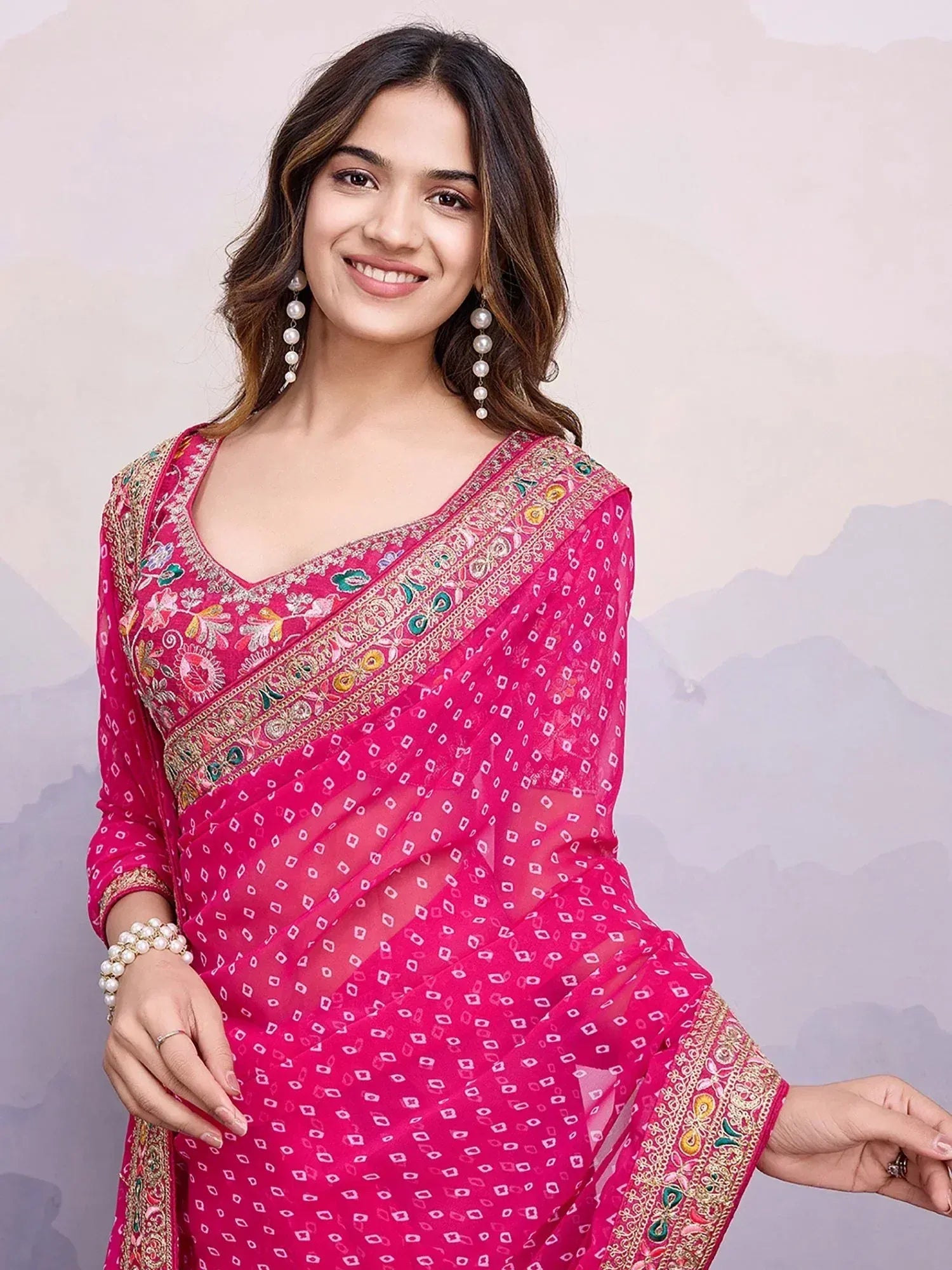 Pink embroidered ethnic saree with floral border and pearl jewelry, perfect for Indian occasions