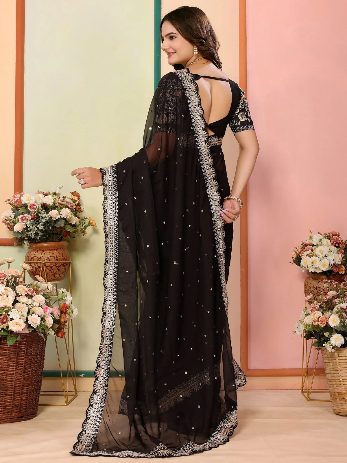 Black embroidered saree with gold detailing, backless blouse, and sheer dupatta for ethnic wear