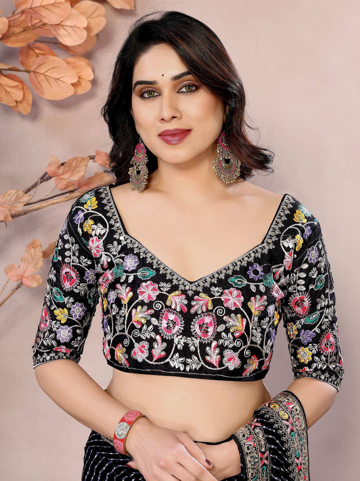 Black floral embroidered blouse with colorful designs, paired with ethnic wear accessories