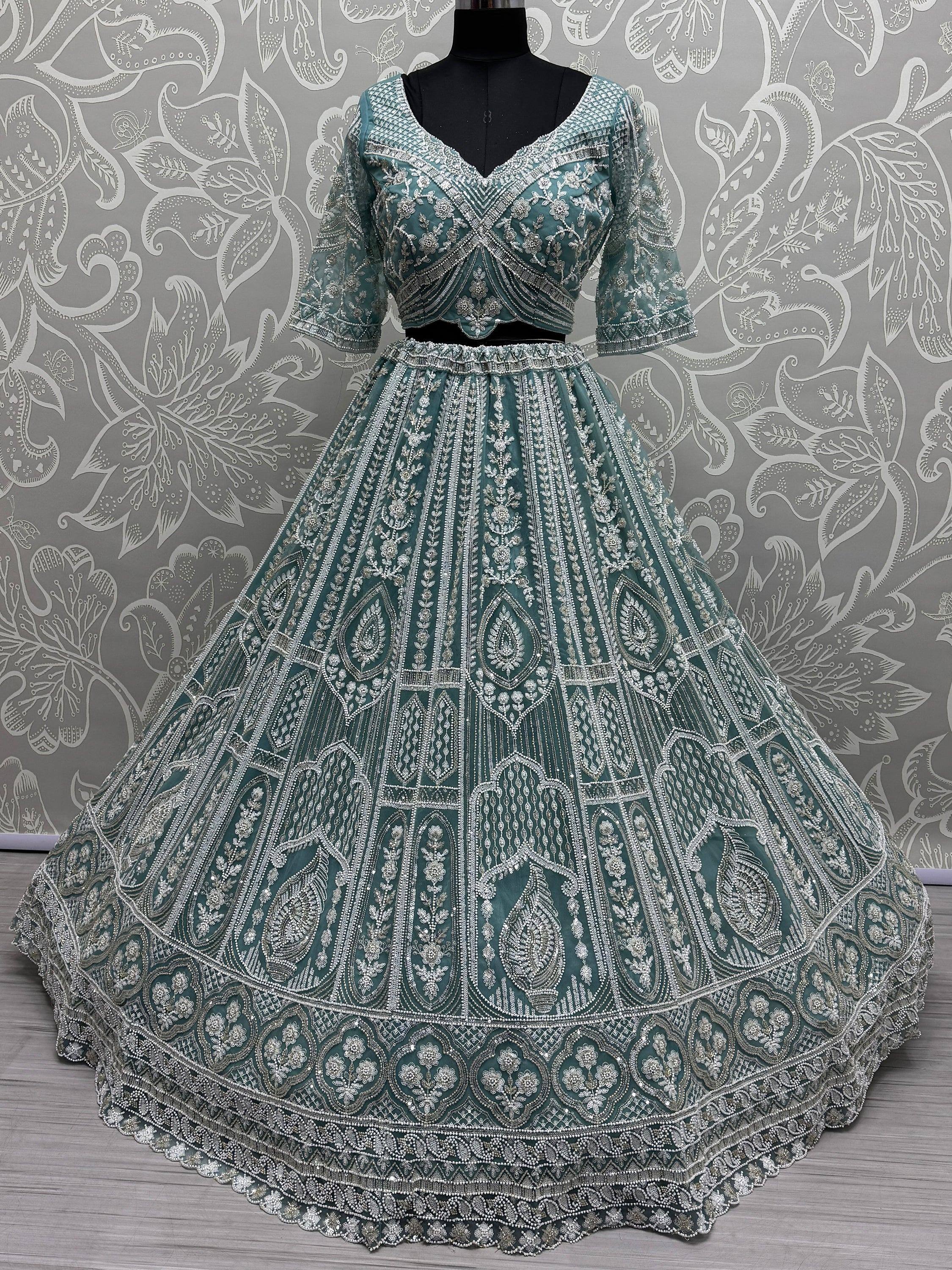 Teal designer lehenga choli with heavy silver embroidery, perfect for Indian weddings and festive occasions.