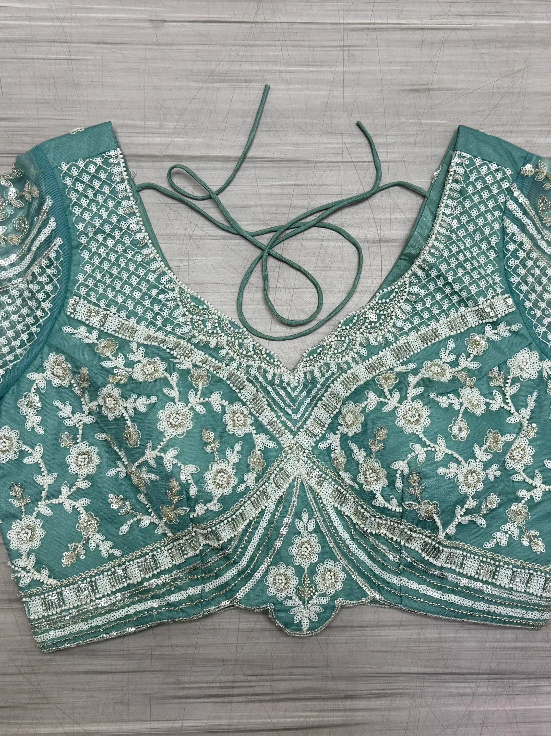 Teal green embroidered blouse with floral sequin work and tie-back detail, ideal for lehenga choli sets