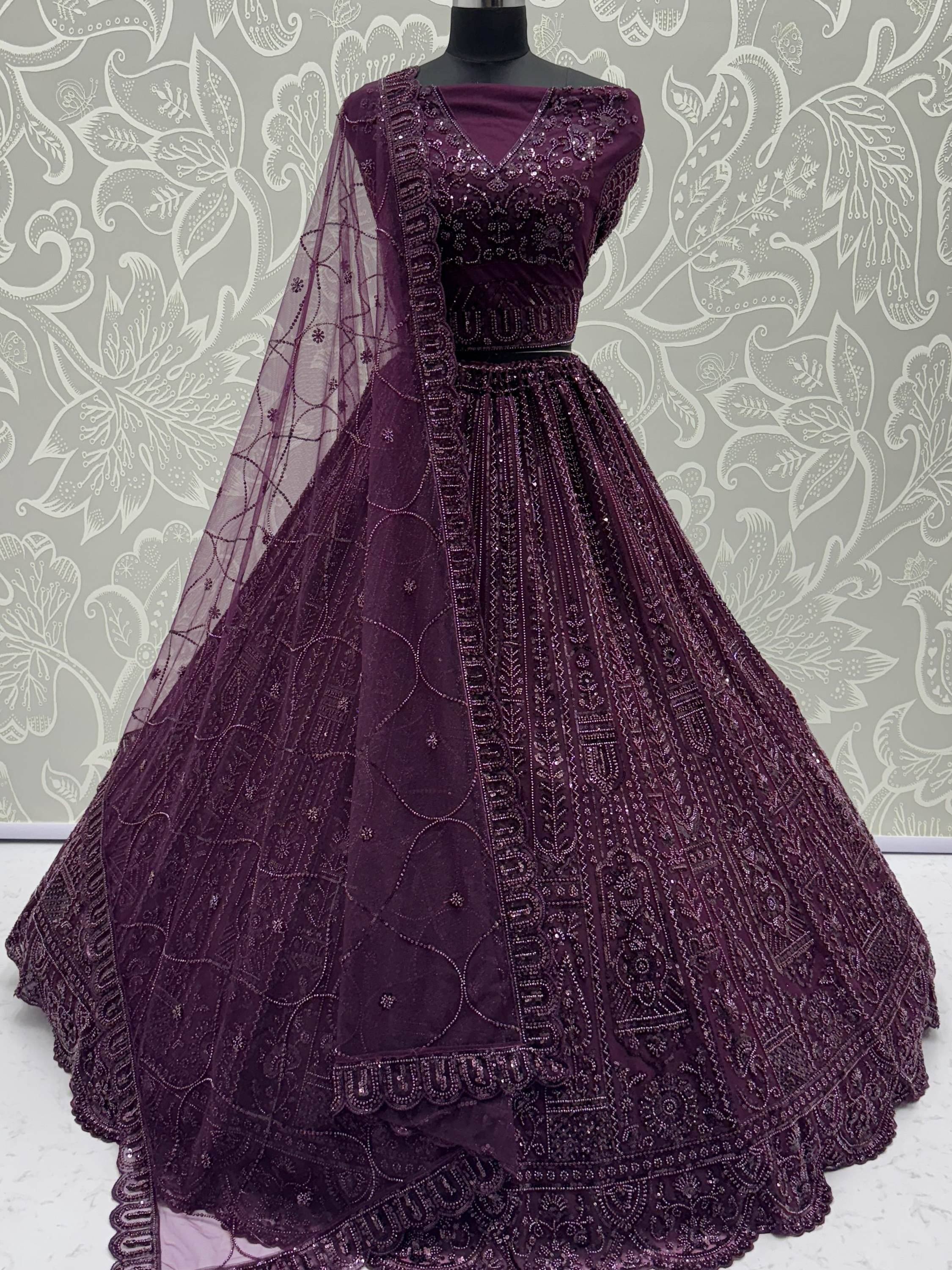 Elegant purple embroidered lehenga choli with net dupatta, perfect for Indian weddings and festive occasions.