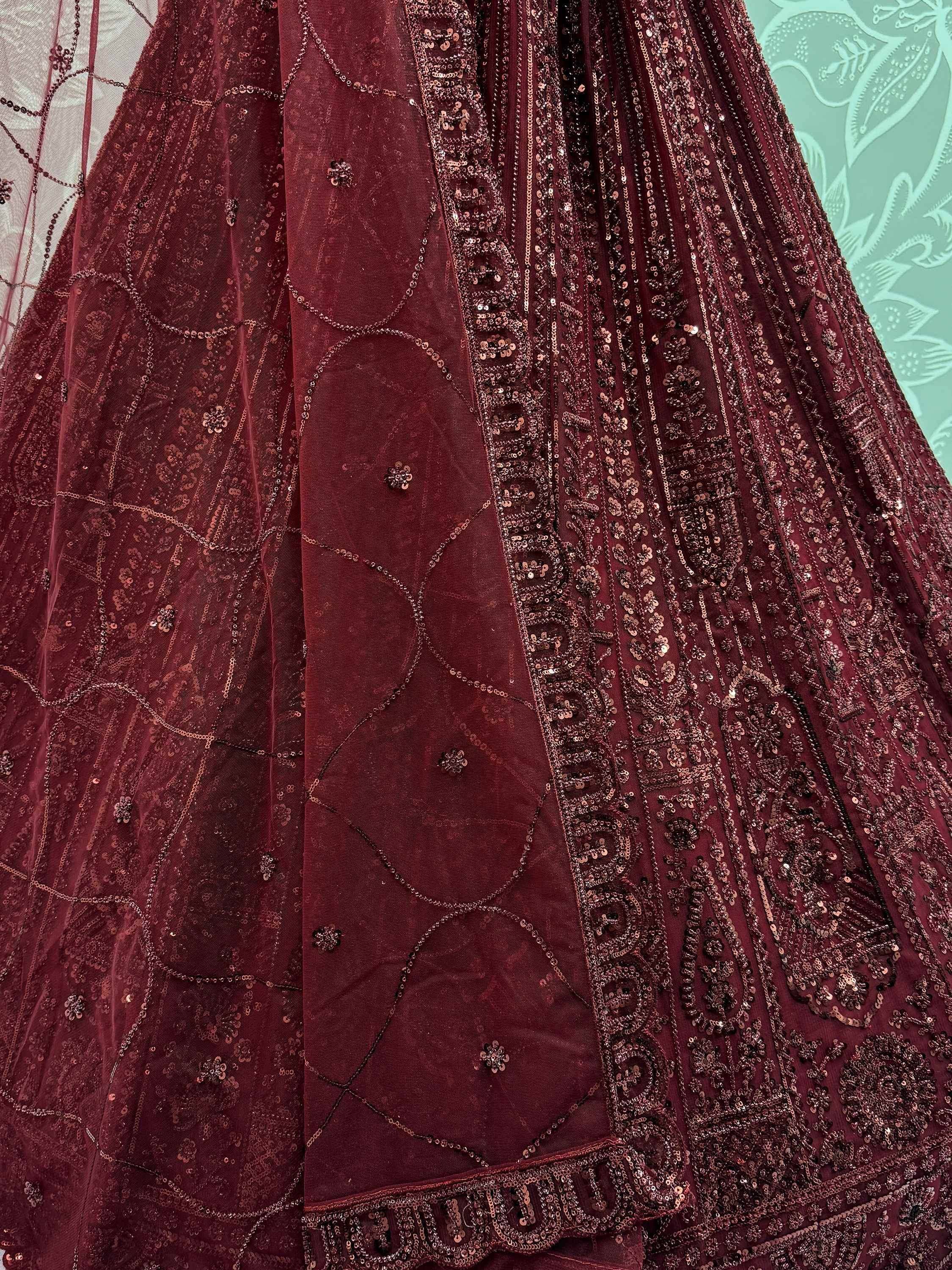 Maroon designer lehenga with intricate sequin and thread embroidery, perfect for Indian ethnic wear occasions.
