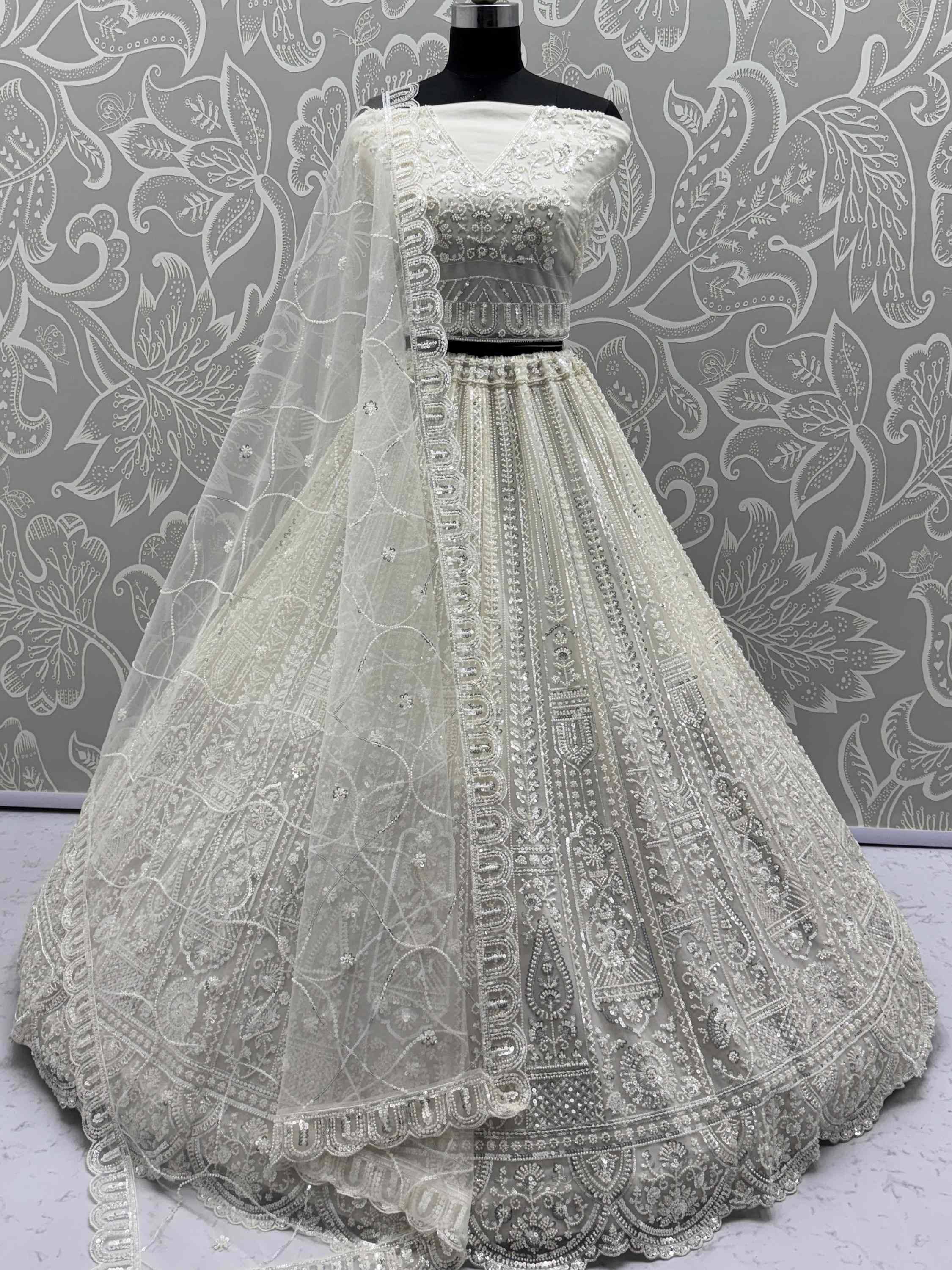 Elegant white designer lehenga choli with heavy embroidery and net dupatta, perfect for Indian weddings and festive occasions.