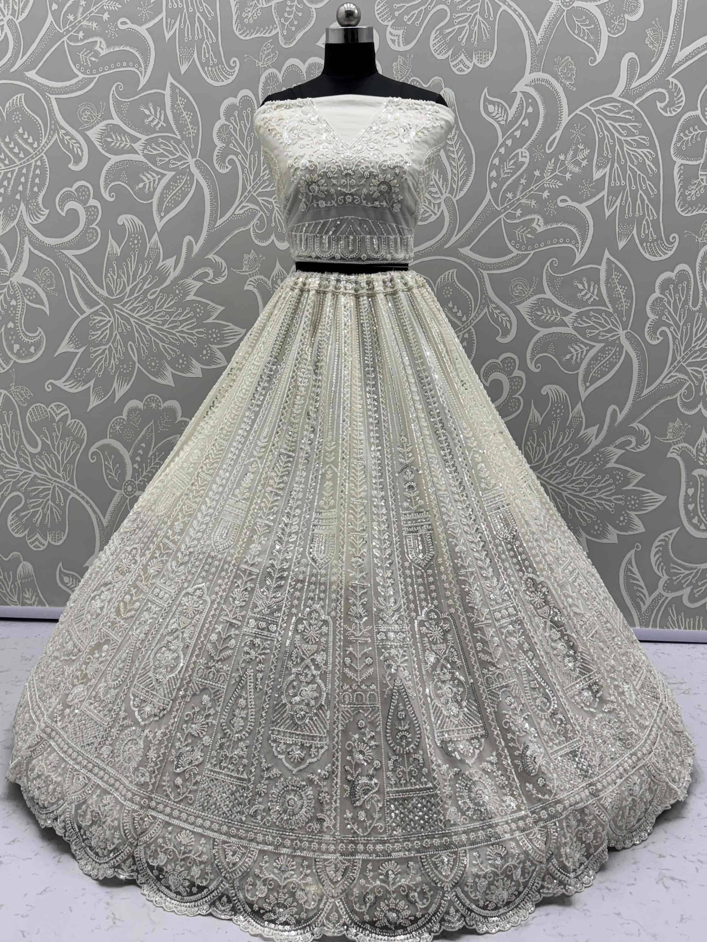 Elegant white designer lehenga choli with intricate embroidery and beadwork, perfect for weddings and festive occasions.