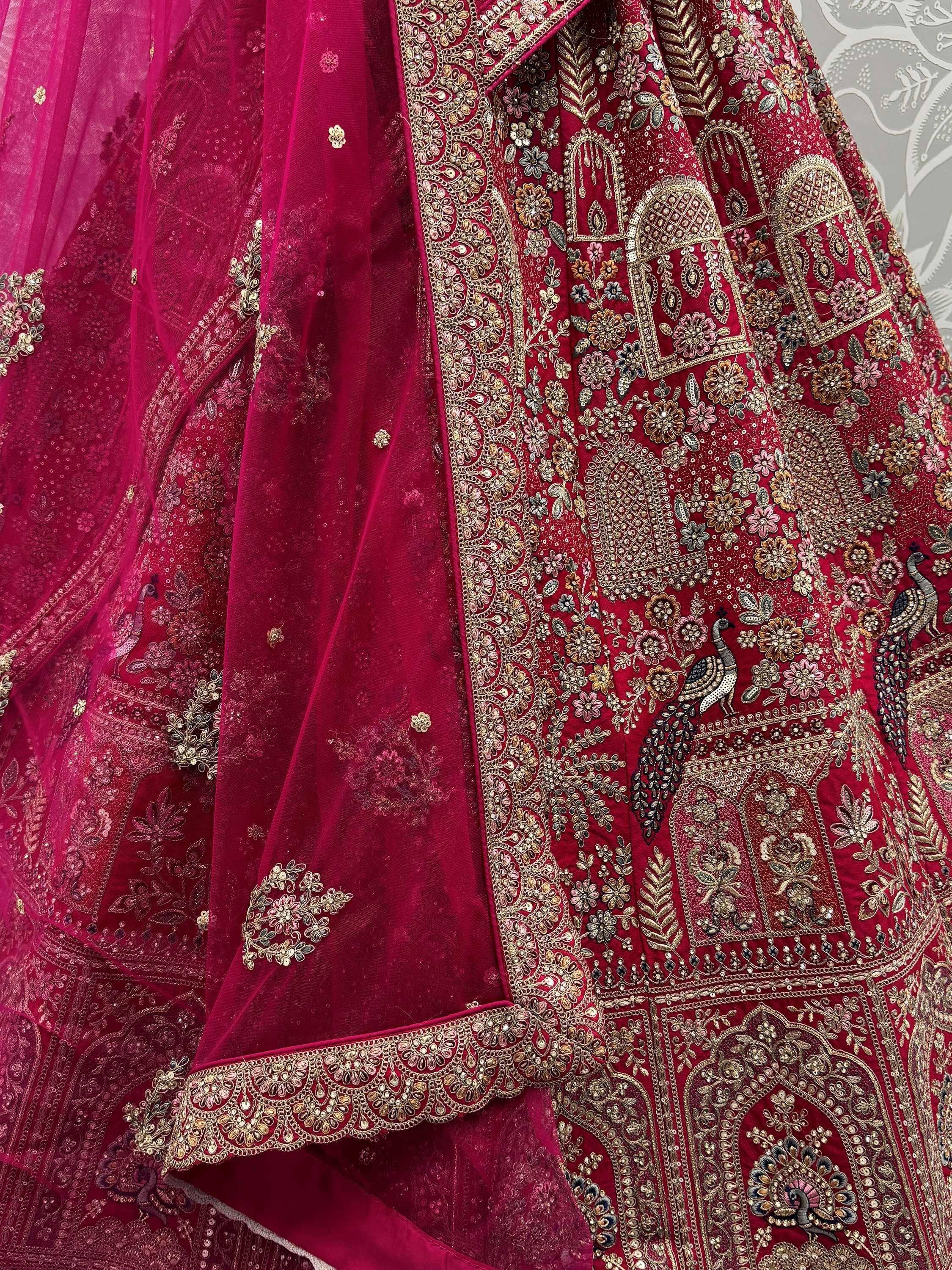 Rich maroon lehenga choli with intricate gold embroidery, floral motifs, and peacock designs for Indian ethnic wear.