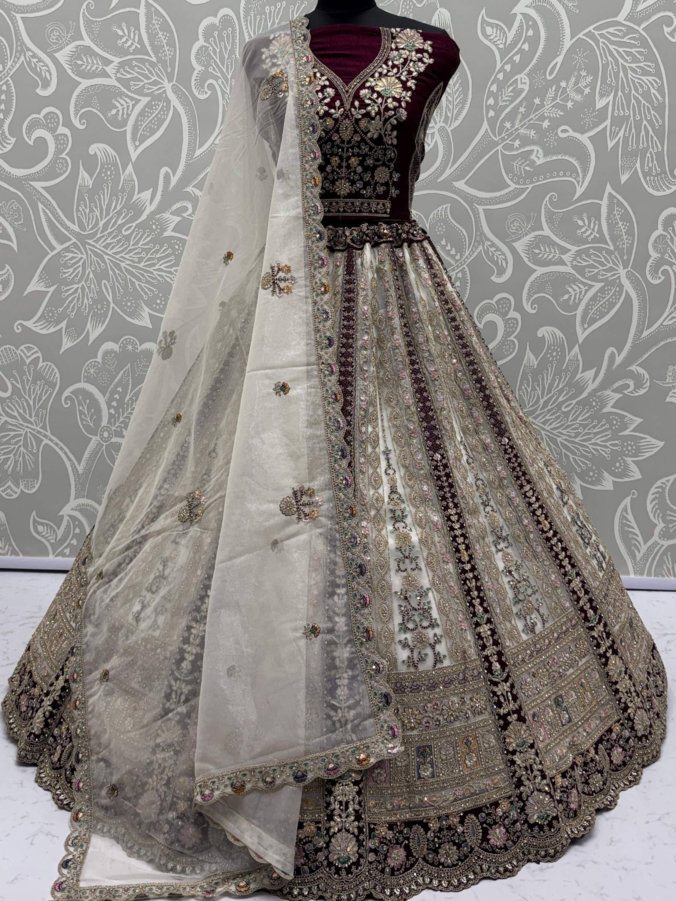 Elegant maroon and ivory designer lehenga choli with heavy embroidery and sheer dupatta, perfect for weddings.