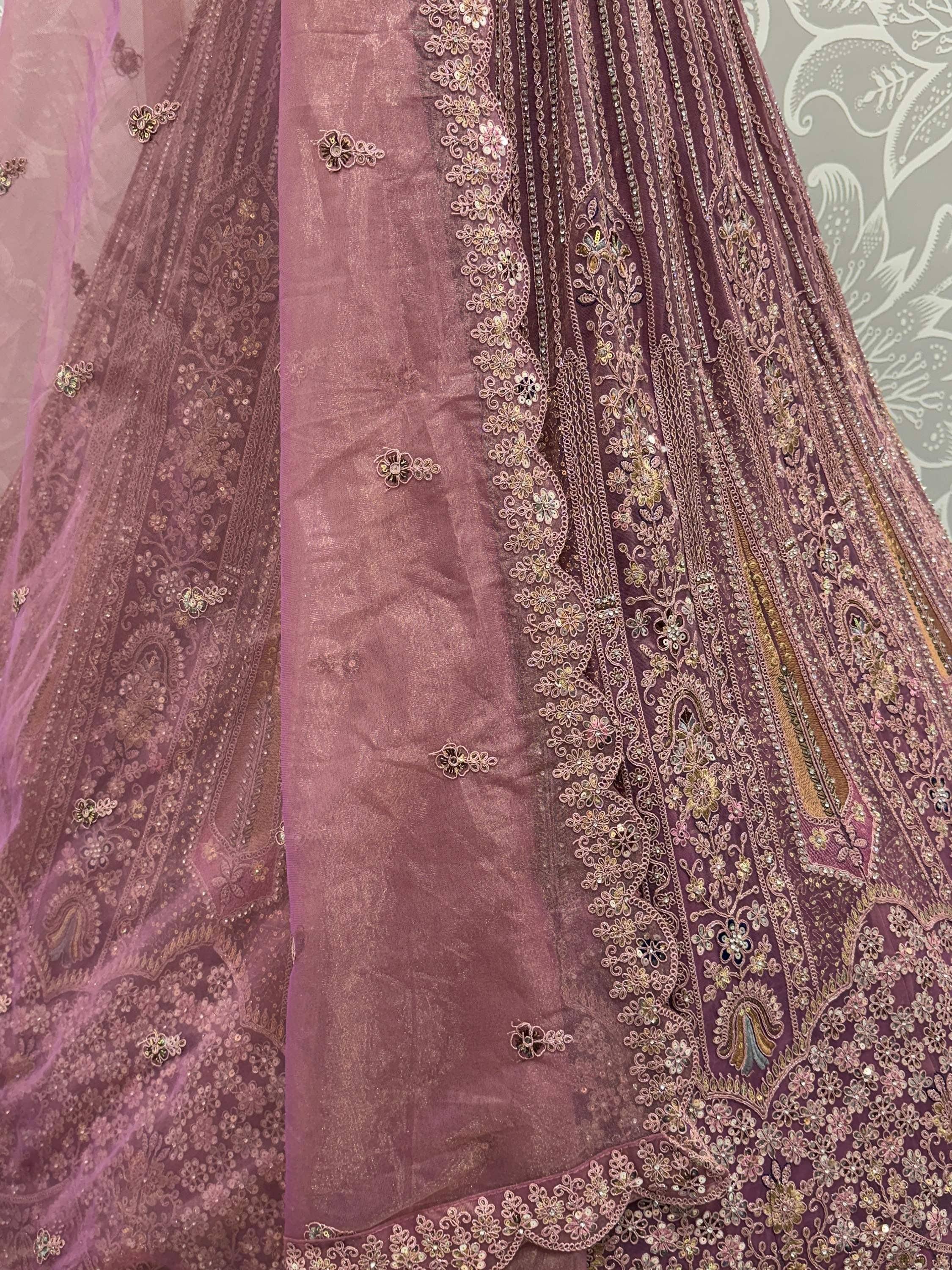 Dusty rose Indian lehenga with intricate gold embroidery and sequin detailing, perfect for weddings or festive occasions.