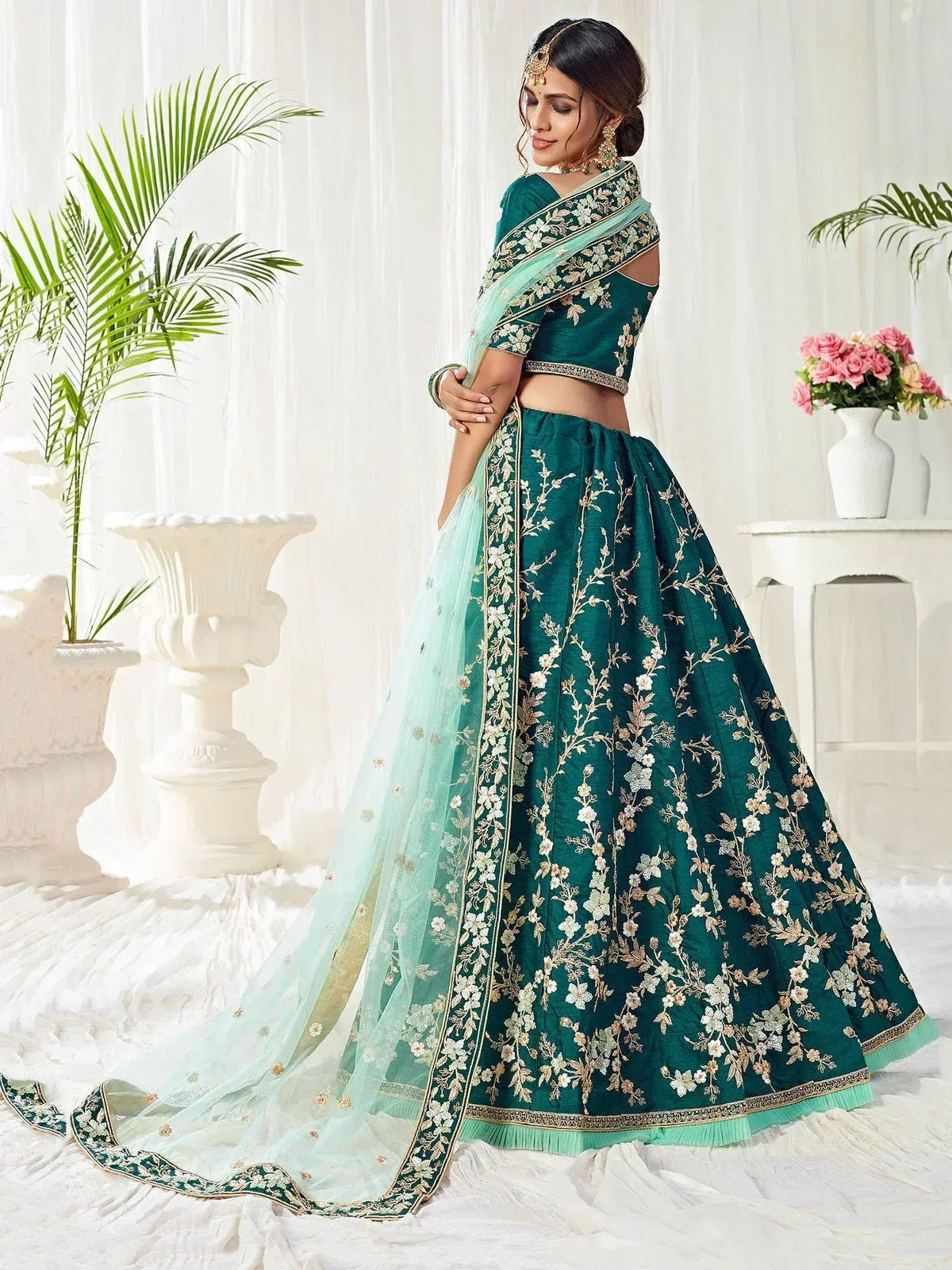 Emerald green designer lehenga choli with floral embroidery and sheer dupatta, perfect for Indian weddings and festive occasions.