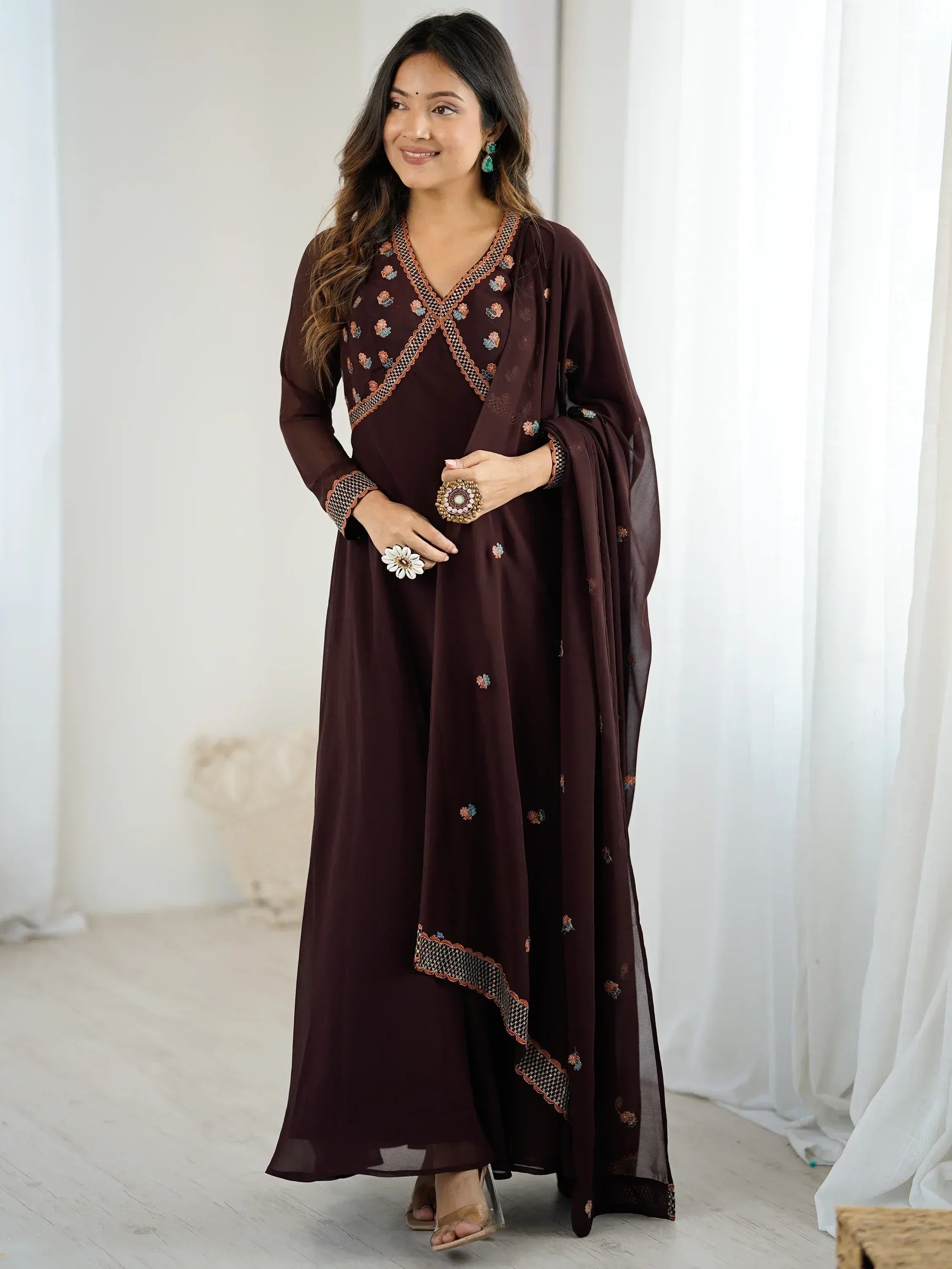 Elegant maroon ethnic gown with floral embroidery and sheer dupatta, perfect for Indian occasions.