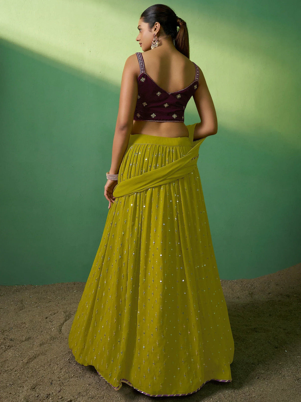 Elegant mustard yellow lehenga with sequin embroidery and maroon velvet blouse, perfect for Indian ethnic wear occasions.