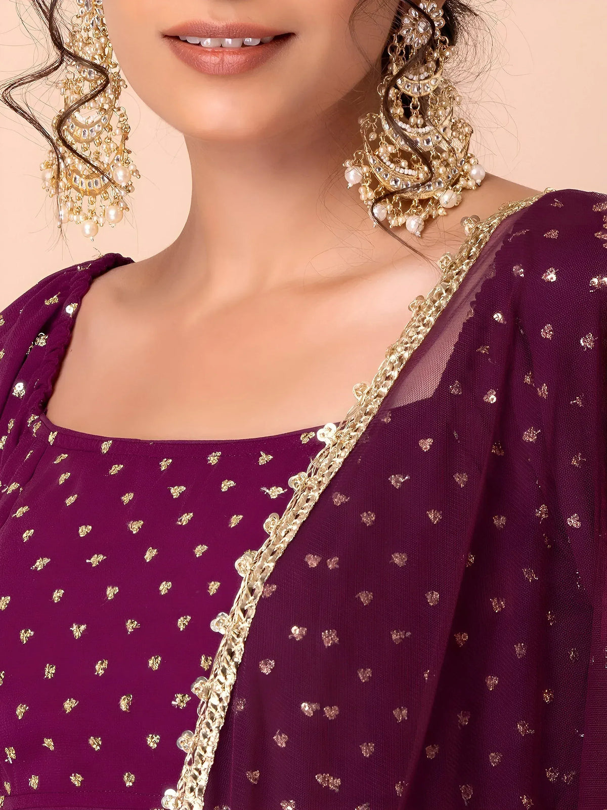 Purple ethnic gown with gold heart prints and embellished neckline, paired with ornate pearl earrings