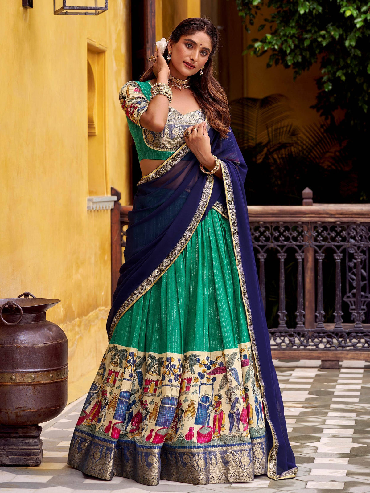 Woman in green and blue printed lehenga choli with ethnic motifs, perfect for Indian weddings or festivals