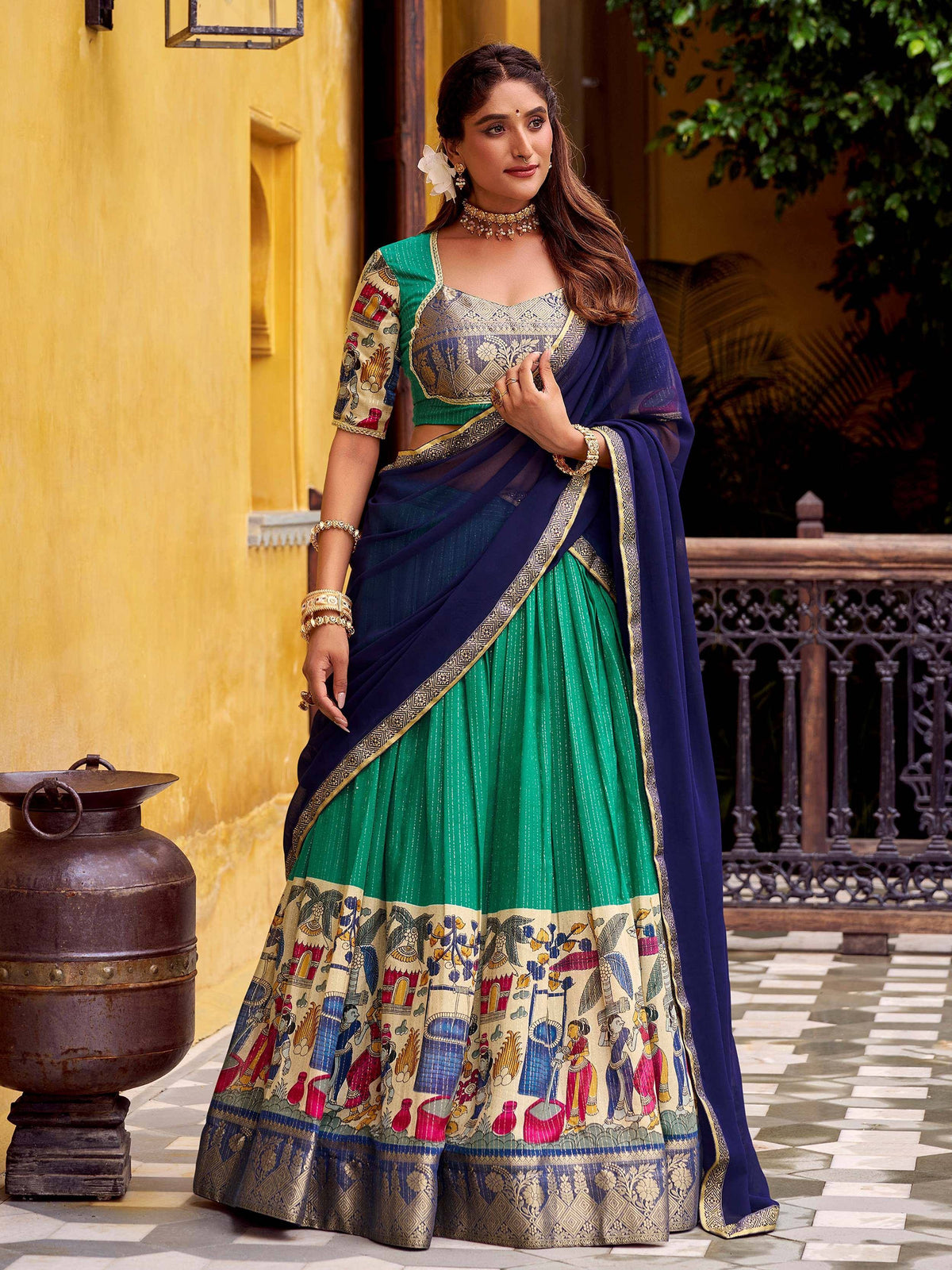 Green and navy blue printed lehenga choli with ethnic motifs, perfect for Indian weddings and festive occasions.